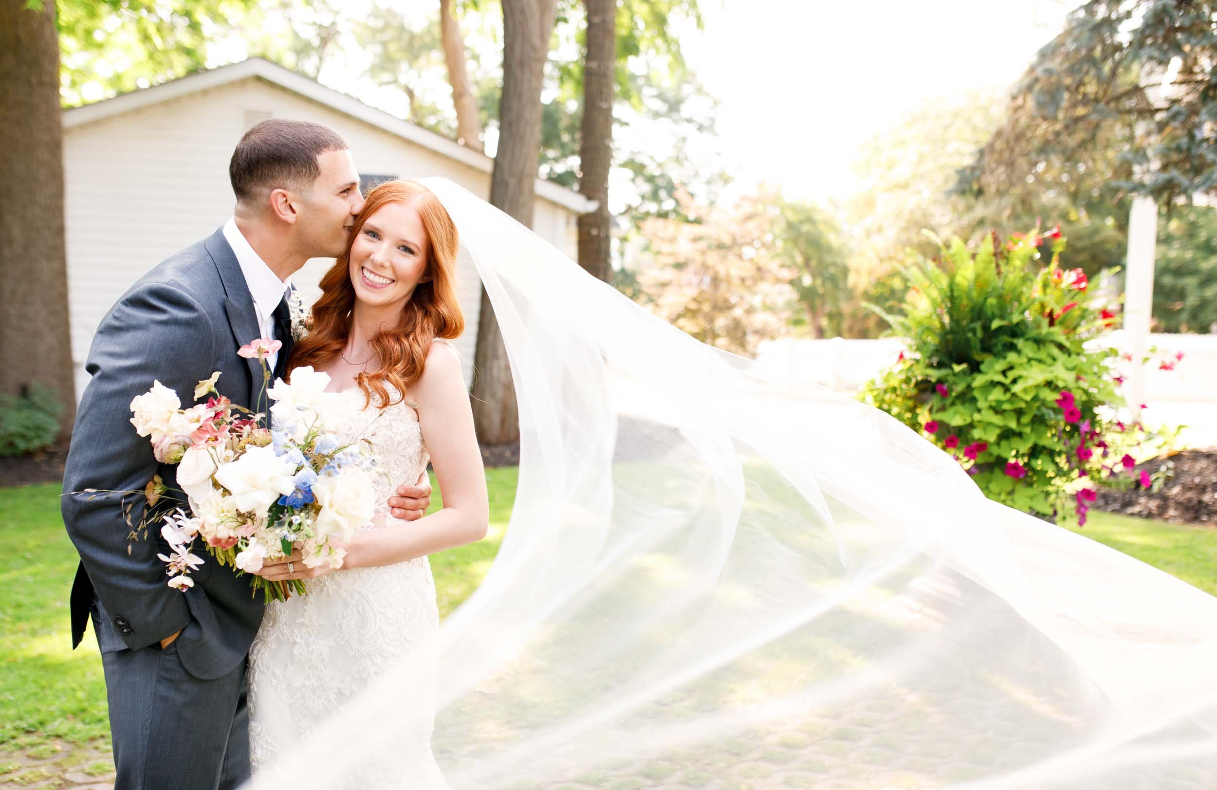 Bride and groom under veil outdoors at The Doctor’s House in Kleinburg