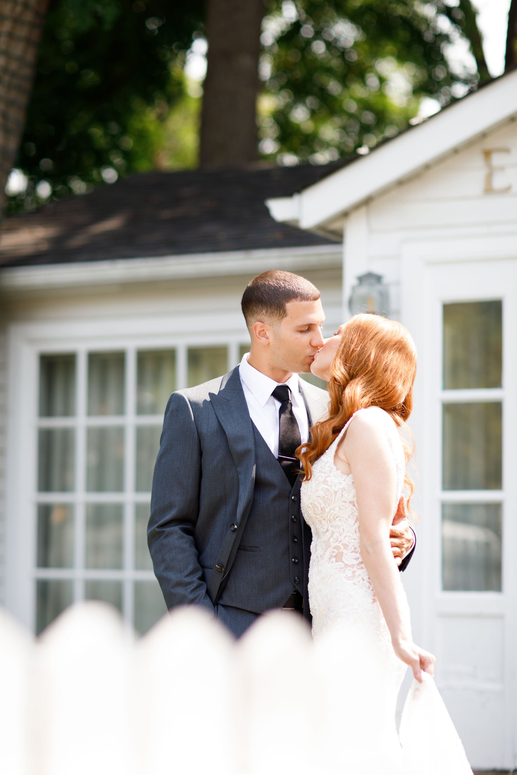 Bride and groom kissing outside Essence at The Doctor’s House in Kleinburg, Ontario