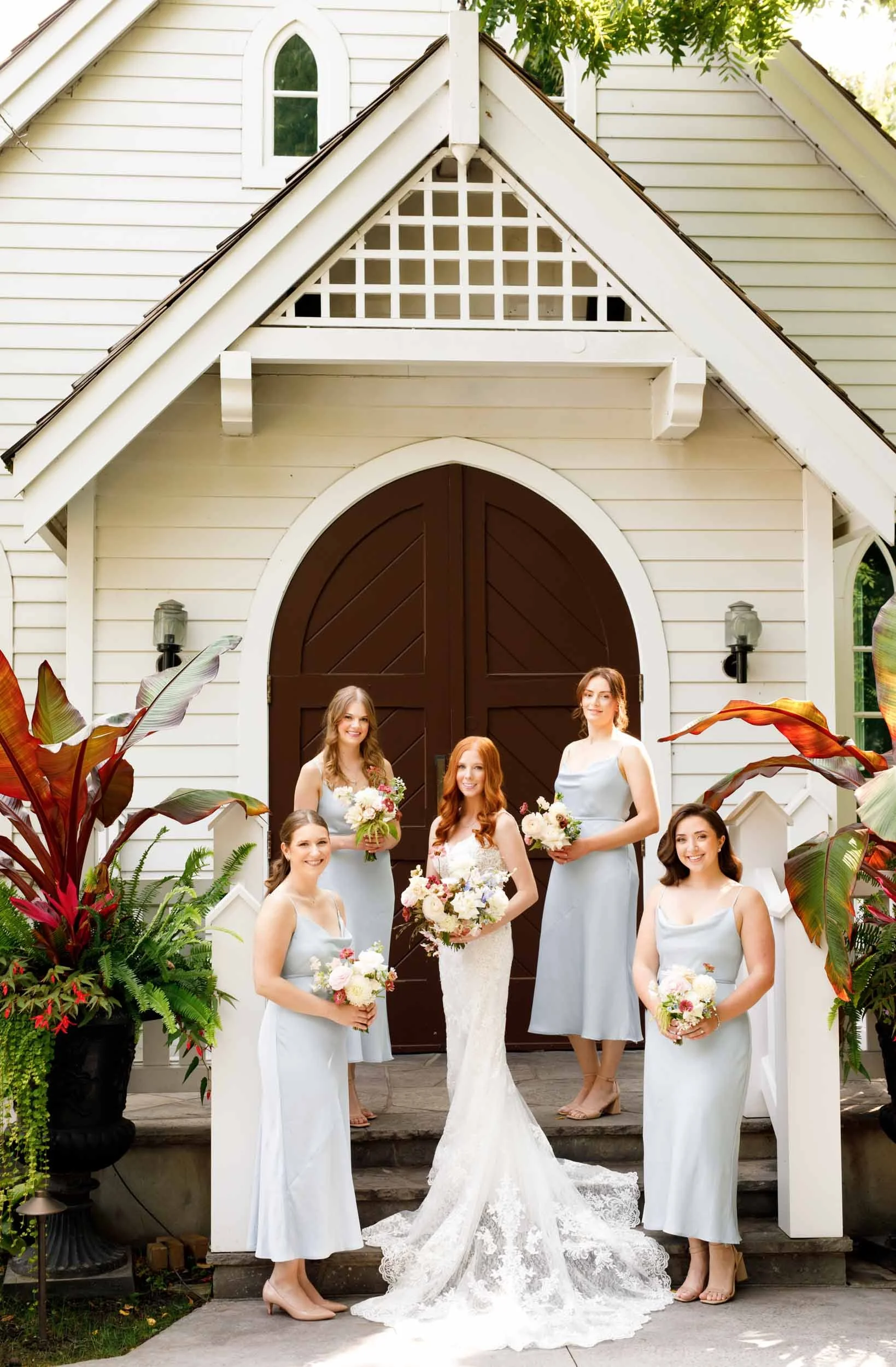 Bride and bridesmaids in front of chapel at The Doctor’s House in Kleinburg, Ontario