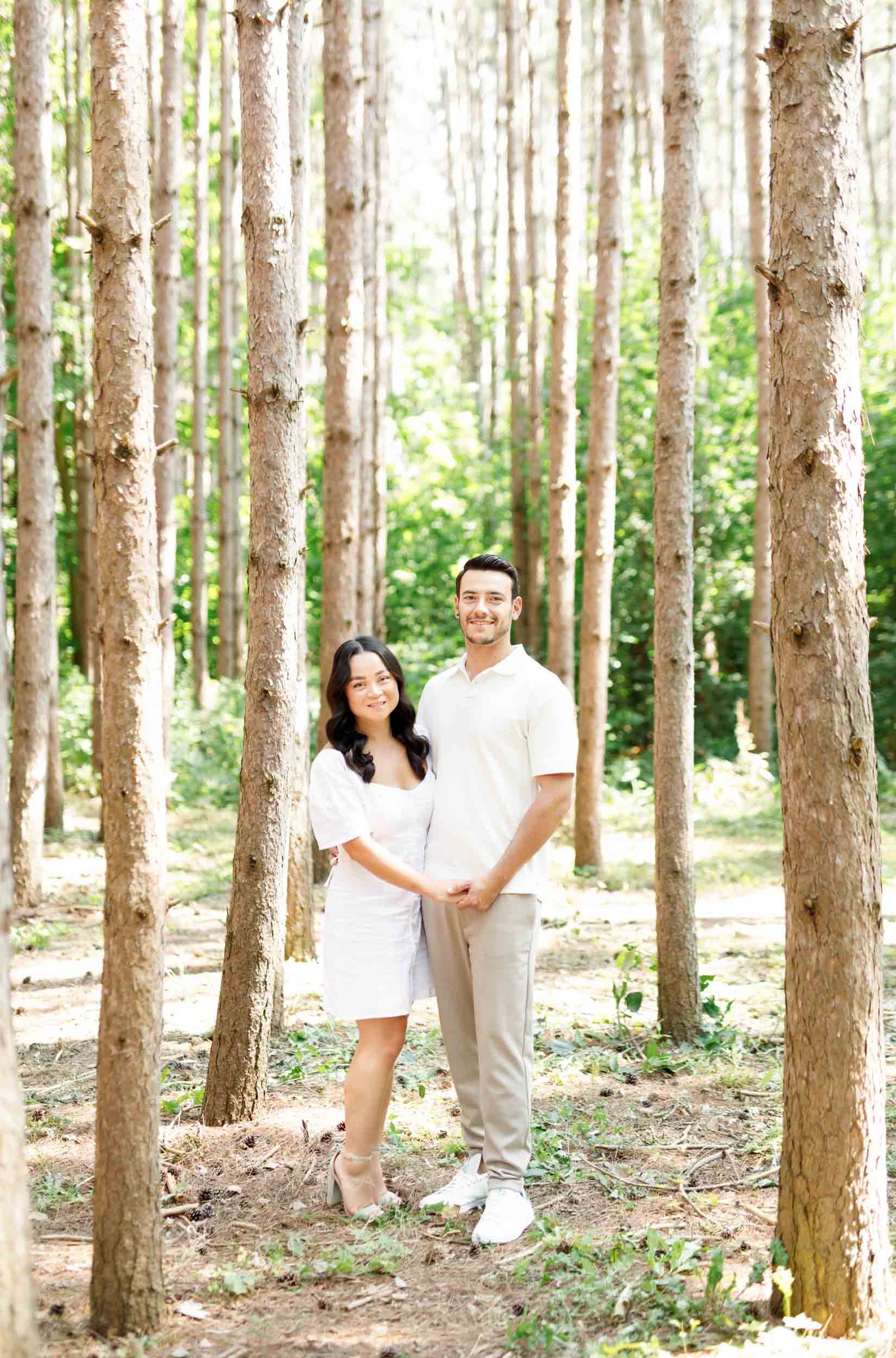 Couple walking hand in hand through pine trees at Kortright Centre for Conservation in Woodbridge, Ontario