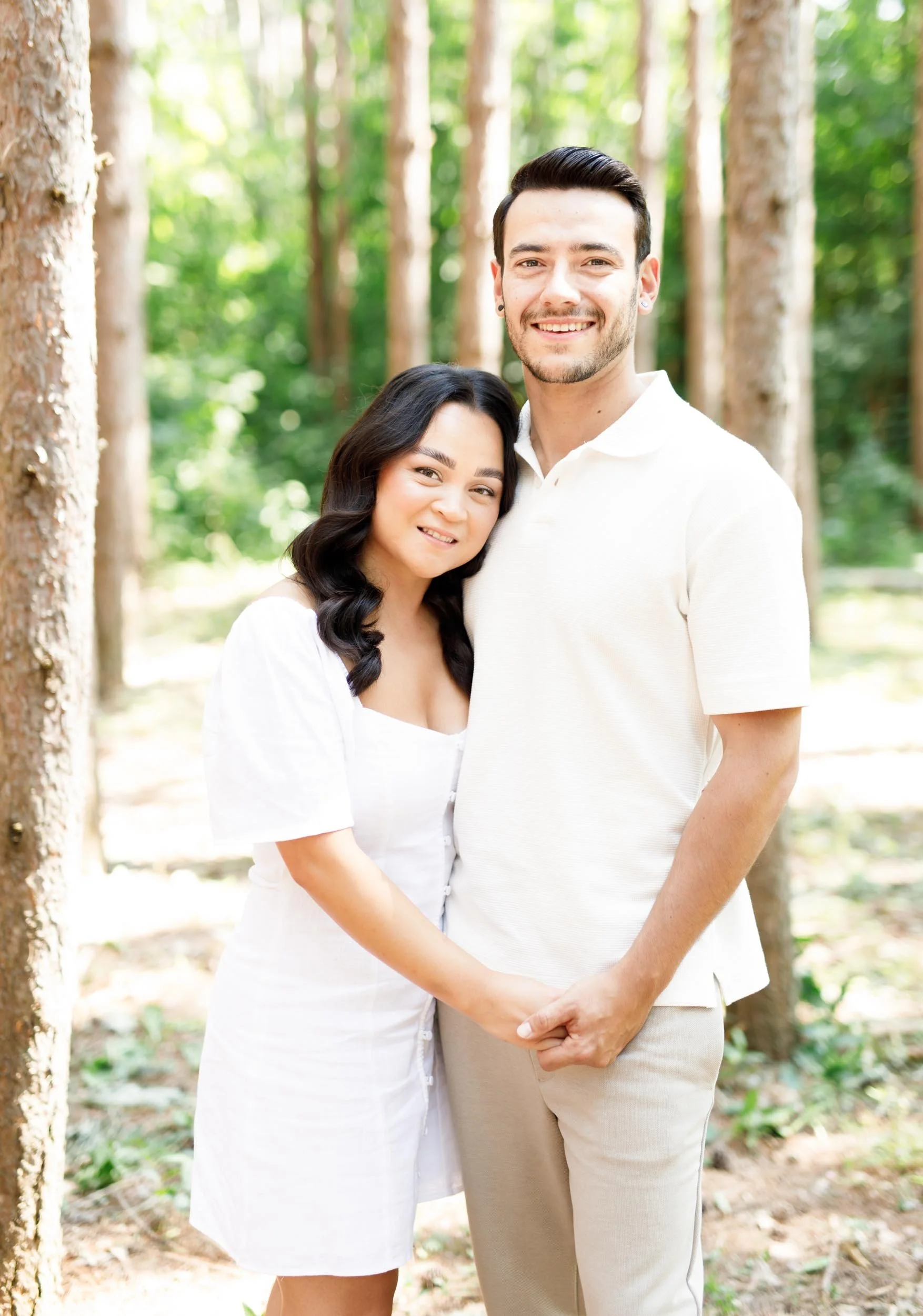Couple holding hands and smiling during engagement portraits at Kortright Centre in Woodbridge, Ontario