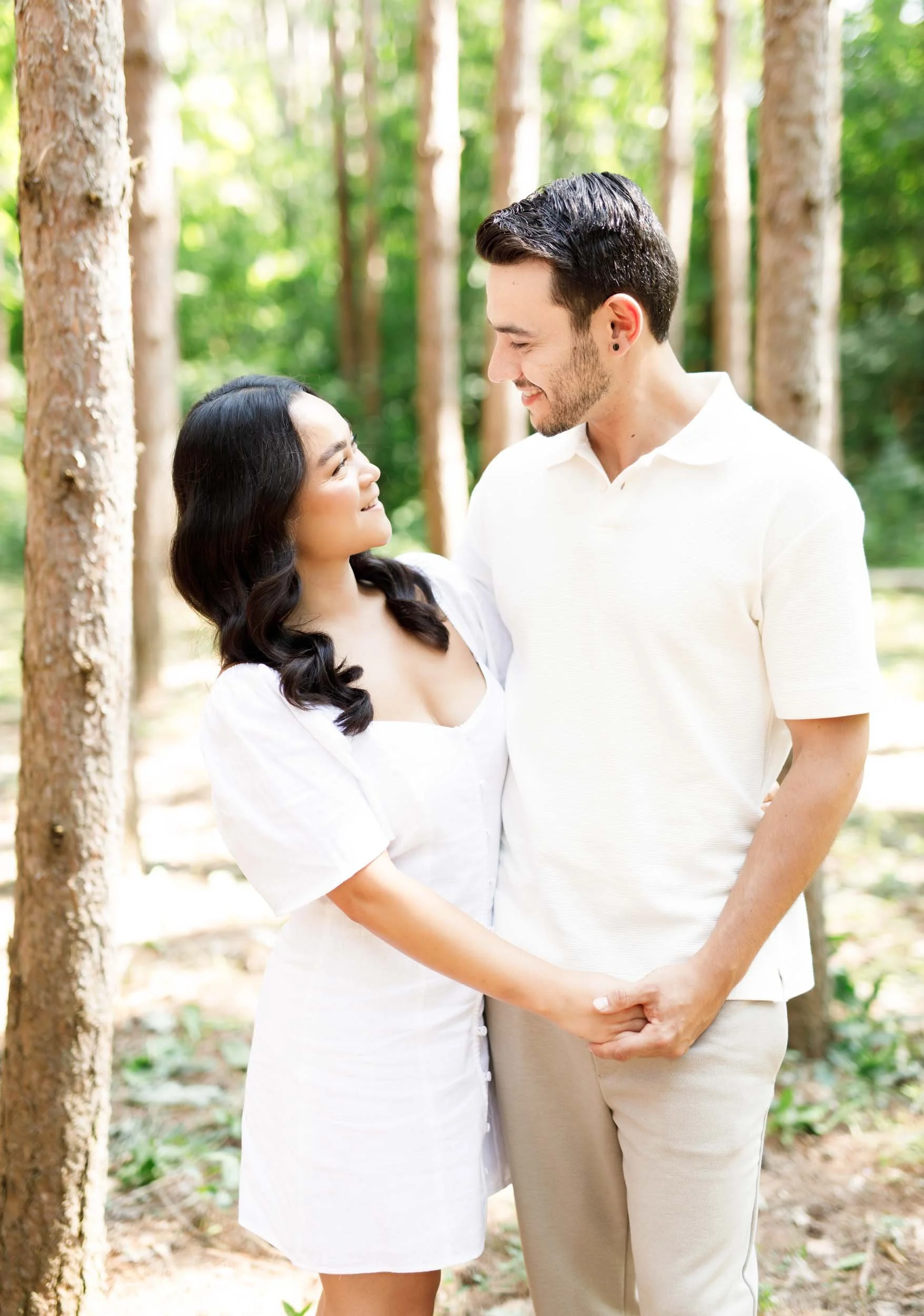 Couple holding hands and smiling during engagement photos at Kortright Centre for Conservation in Woodbridge, Ontario