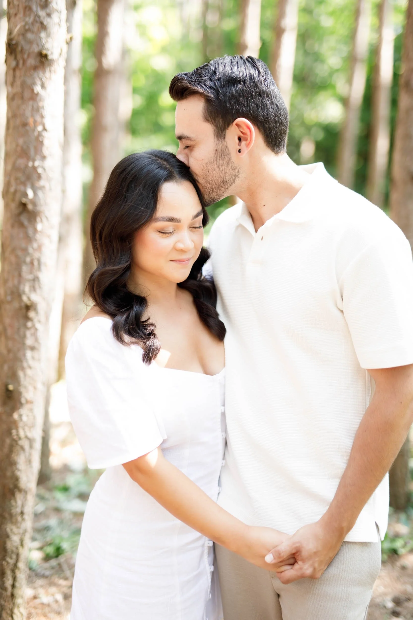 Groom kissing bride’s forehead during their Kortright Centre engagement session in Woodbridge, Ontario