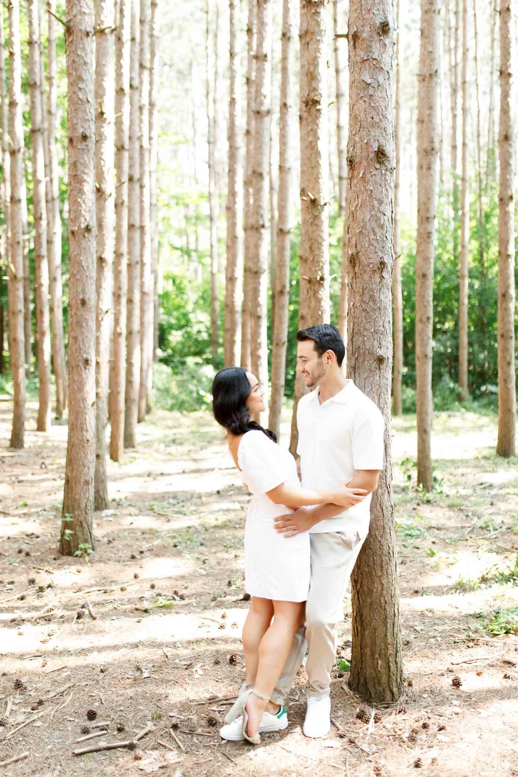 Couple standing together beneath tall trees at Kortright Centre for Conservation in Woodbridge, Ontario