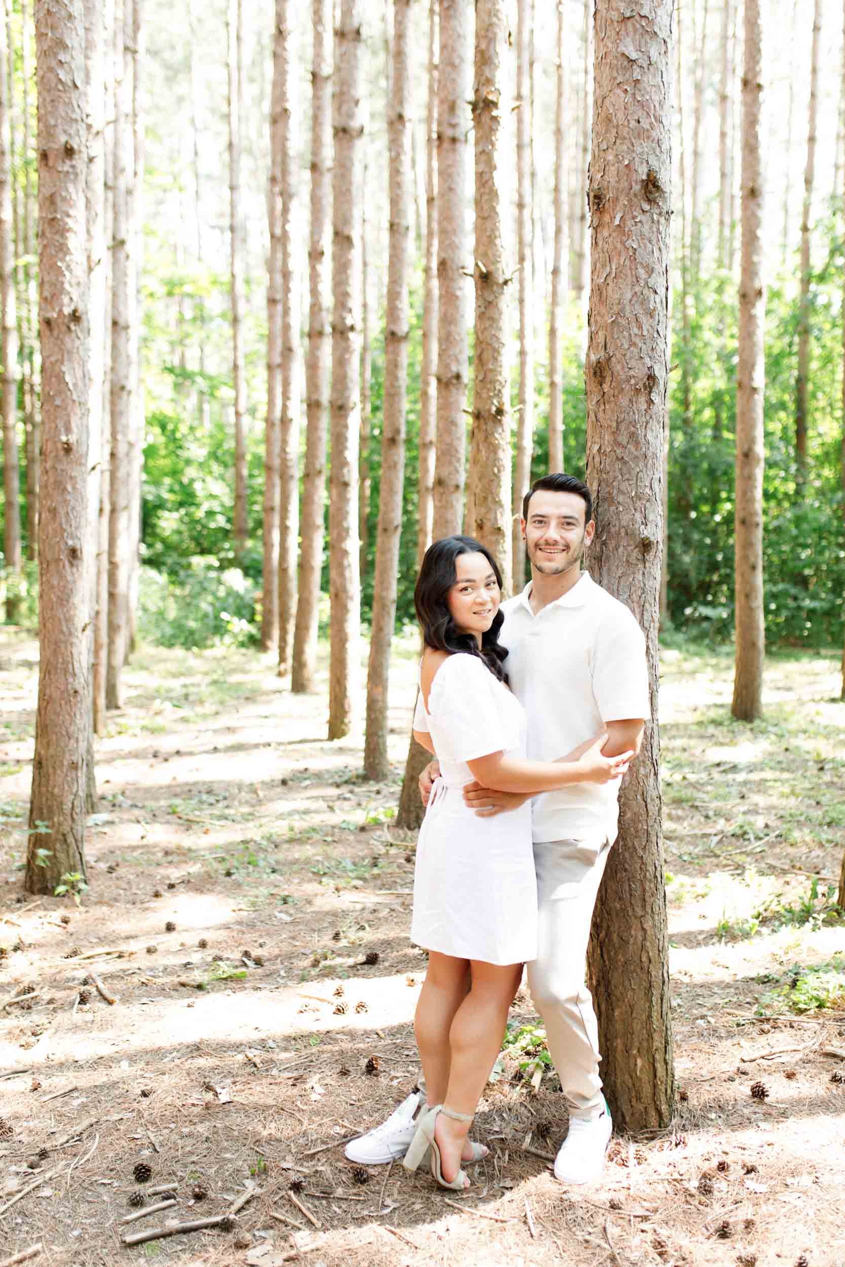 Couple embracing beside a tree during their Kortright Centre engagement in Woodbridge, Ontario