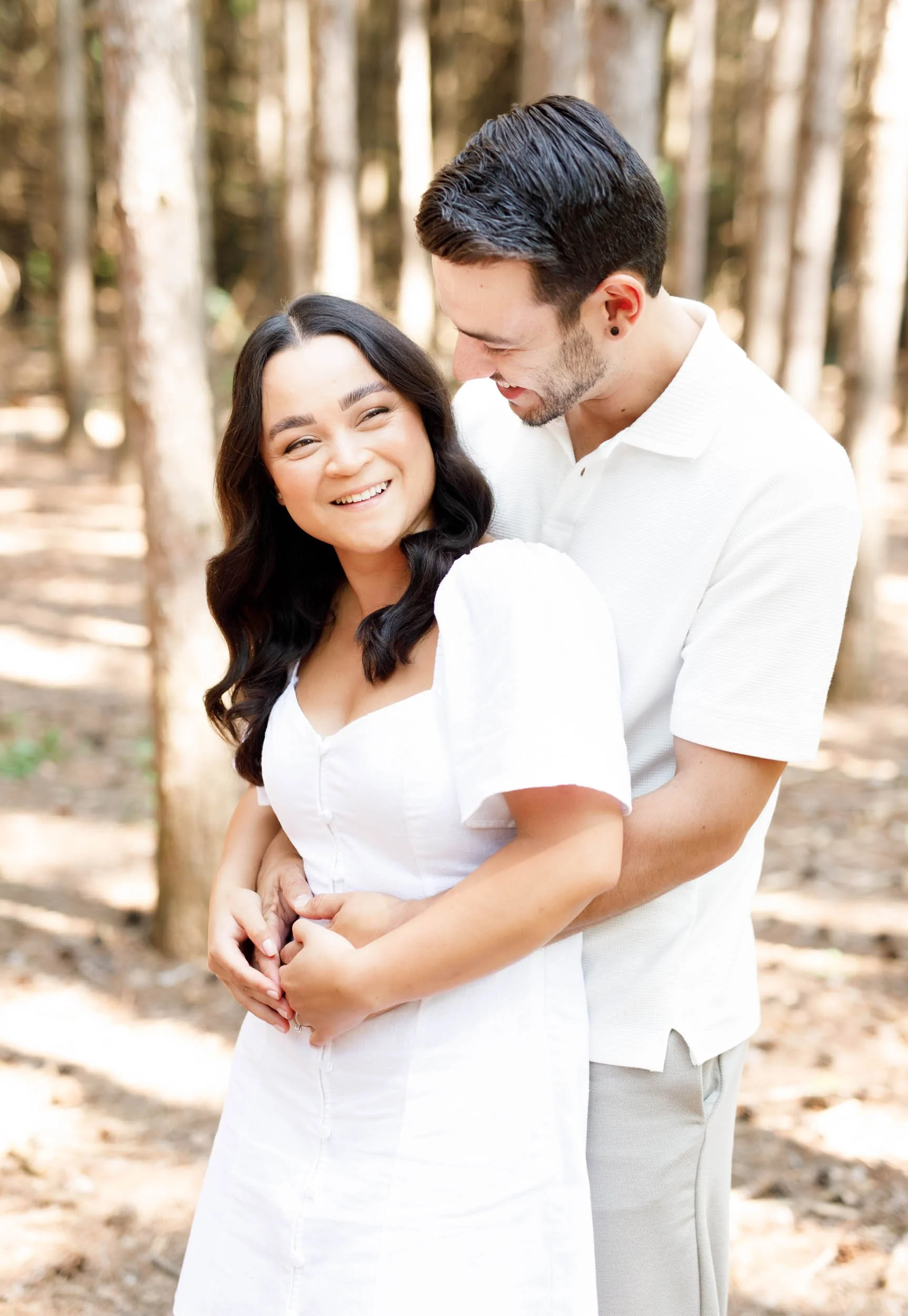 Couple embracing and smiling during their Kortright Centre engagement in Woodbridge, Ontario