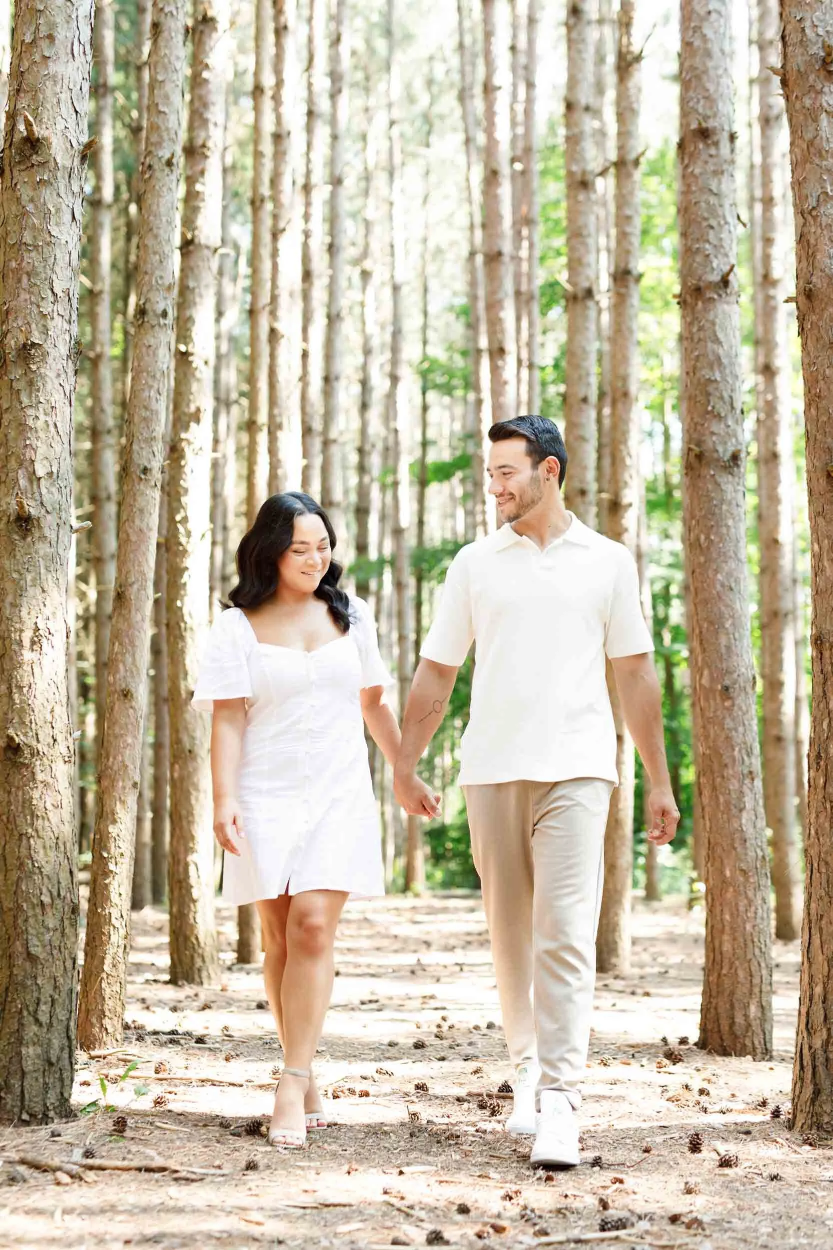 Couple walking hand in hand through the forest at Kortright Centre for Conservation in Woodbridge, Ontario