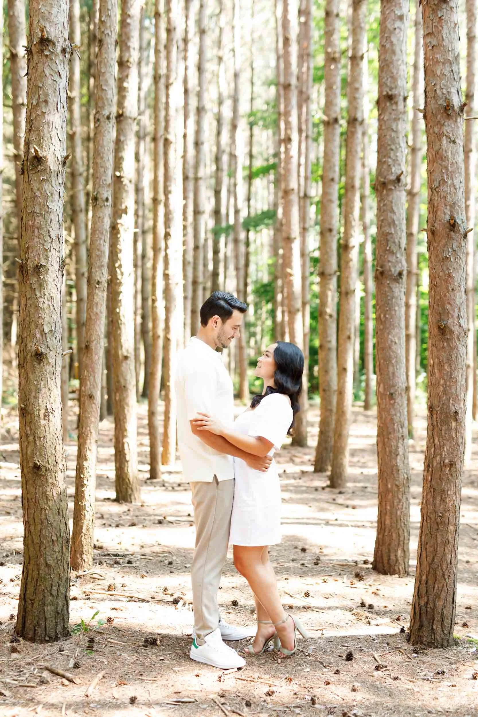 Couple sharing a quiet moment between trees at Kortright Centre for Conservation in Woodbridge, Ontario