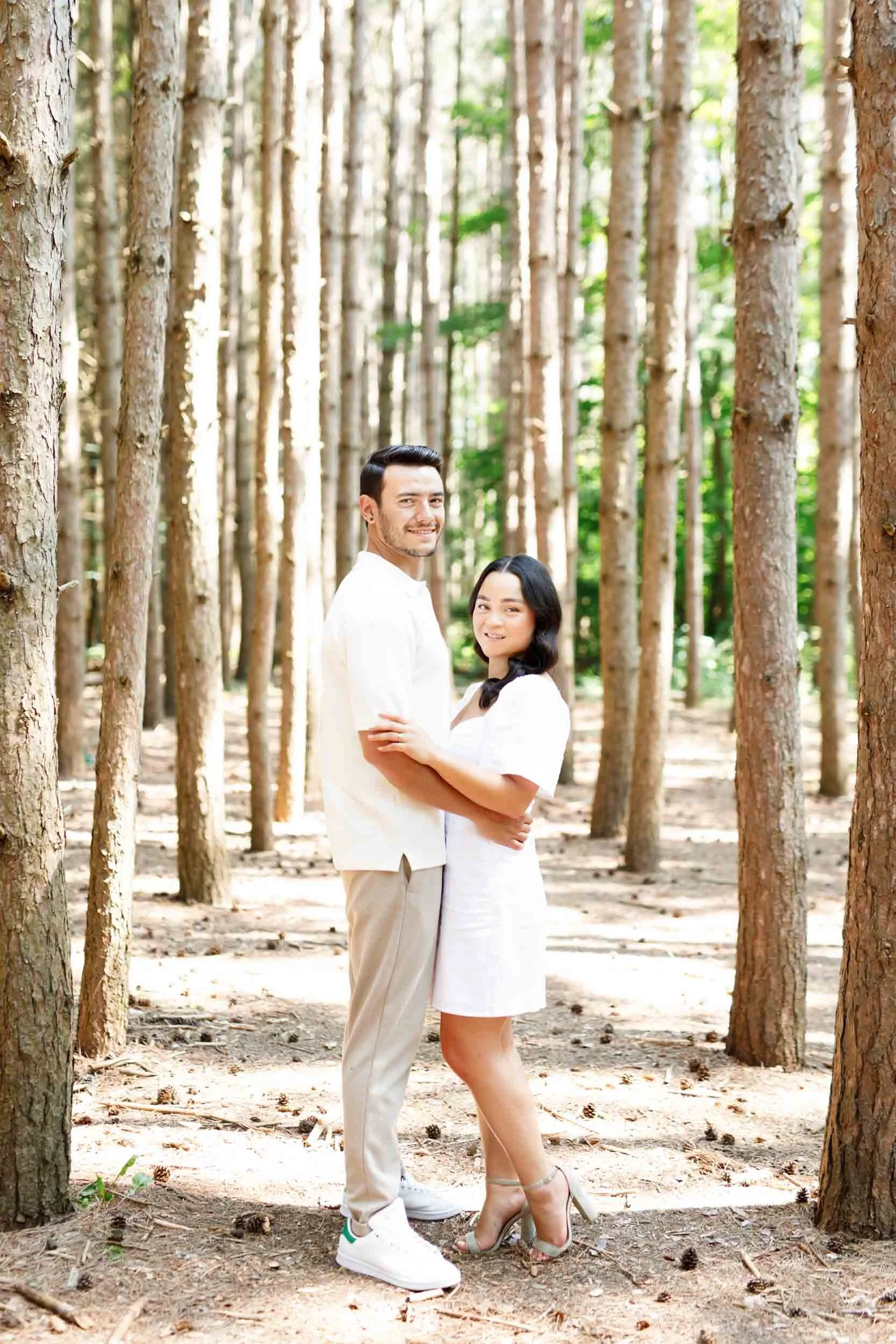 Couple embracing beside a tree during their Kortright Centre engagement in Woodbridge, Ontario