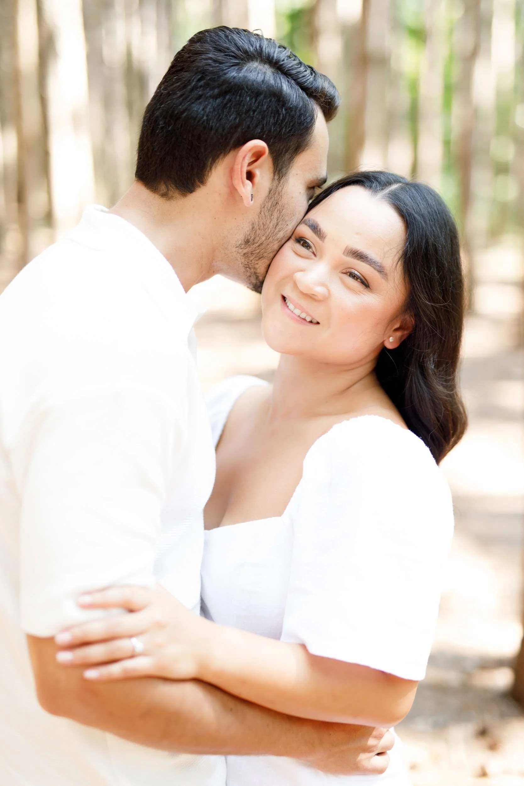 Close-up of couple embracing in soft forest light at Kortright Centre in Woodbridge, Ontario