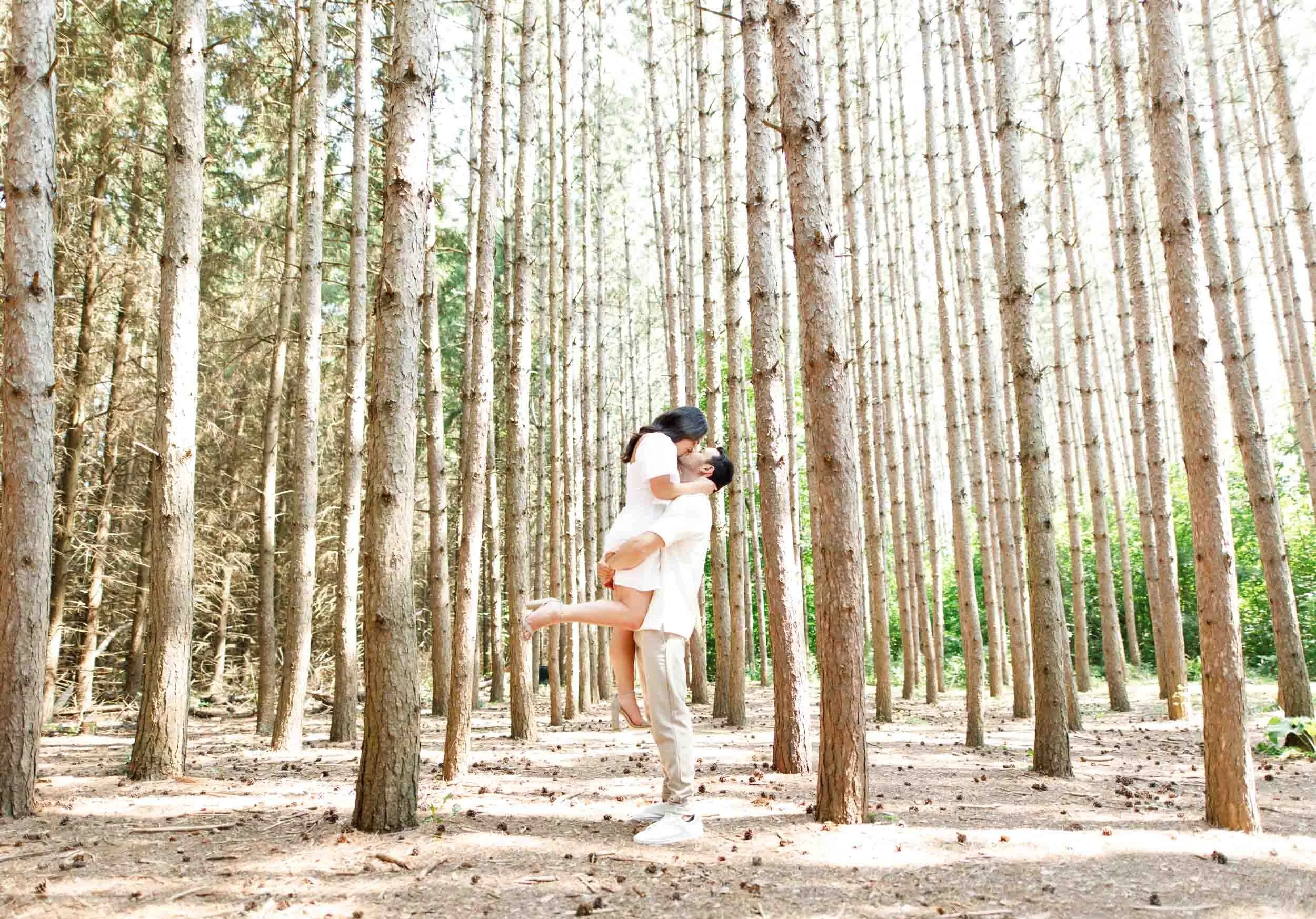 Wide forest portrait of couple surrounded by trees at Kortright Centre for Conservation in Woodbridge, Ontario
