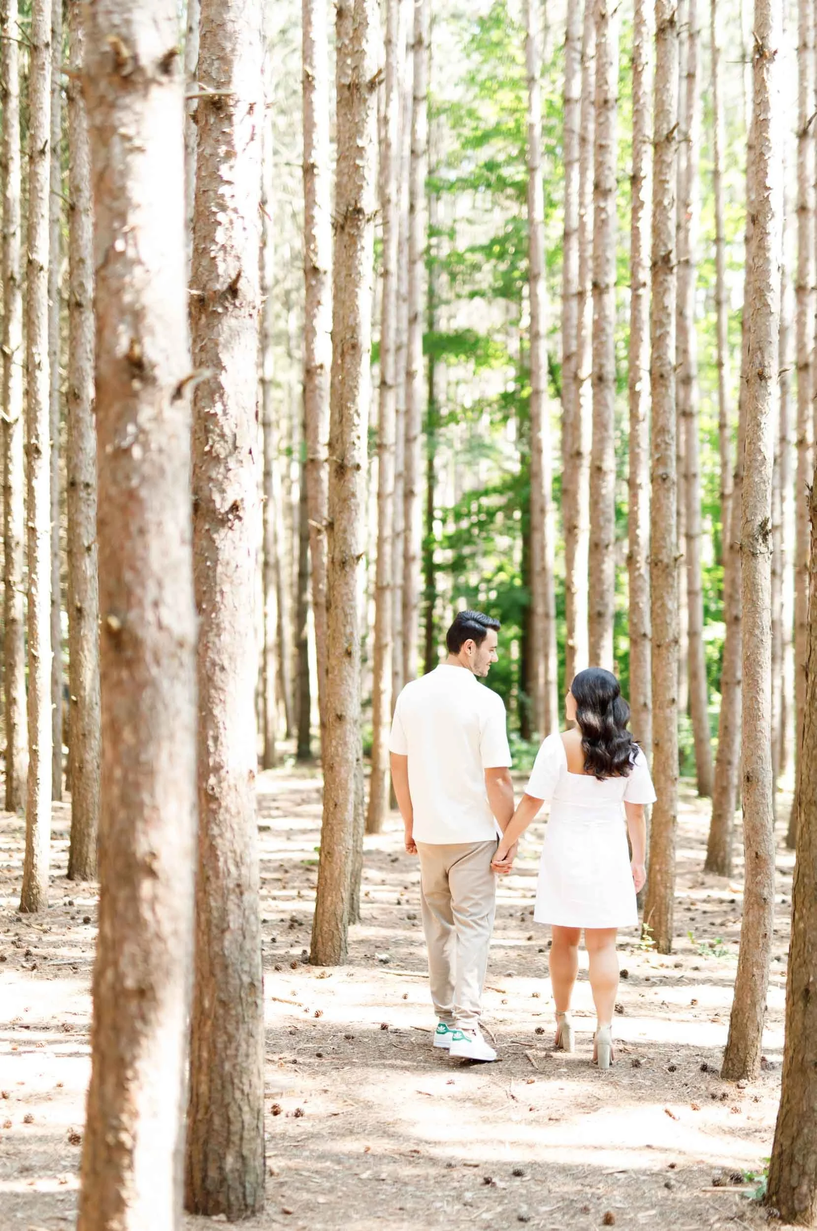 Couple walking together through the pine forest at Kortright Centre in Woodbridge, Ontario