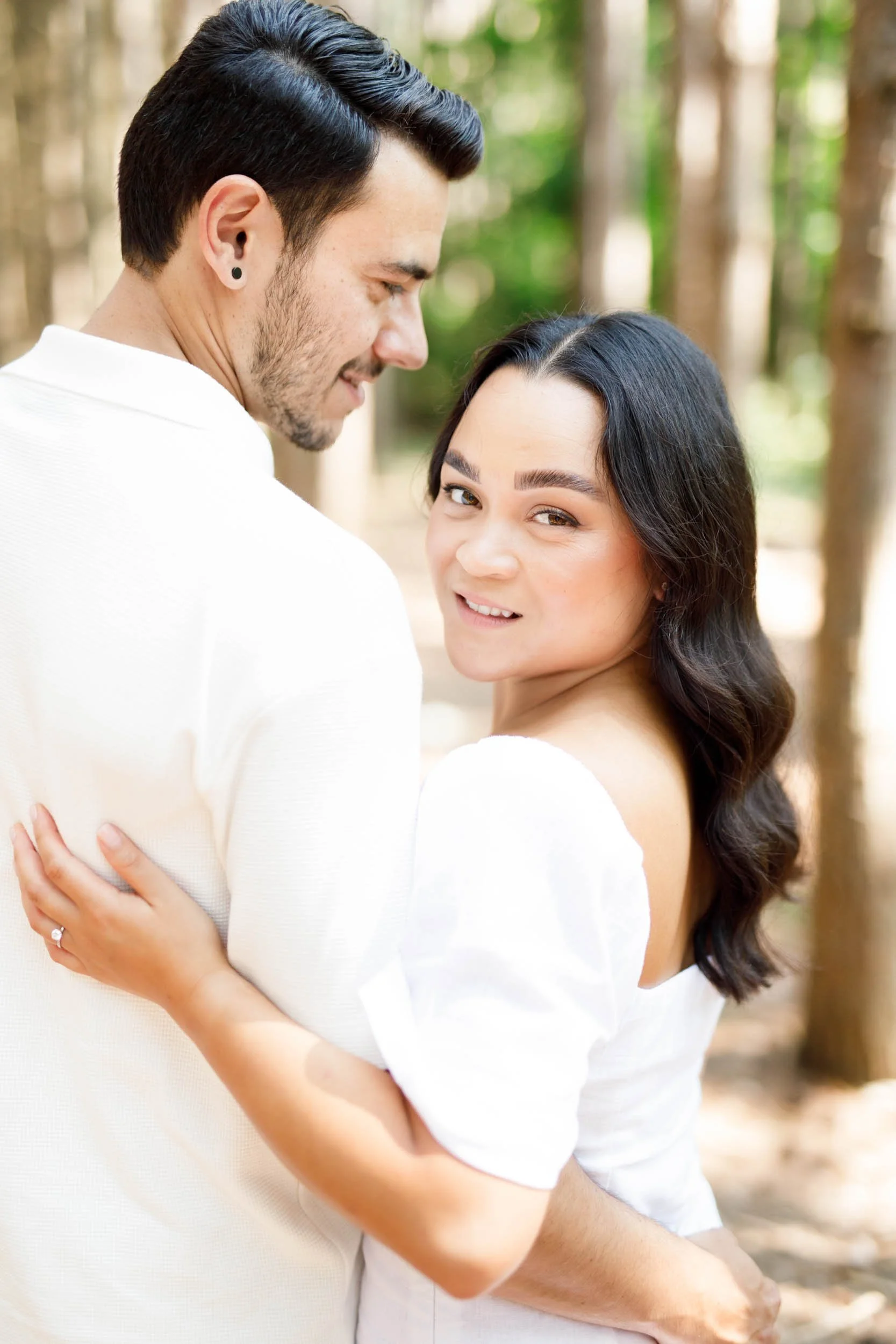 Bride looking back while hugging her fiancé during Kortright Centre engagement in Woodbridge, Ontario