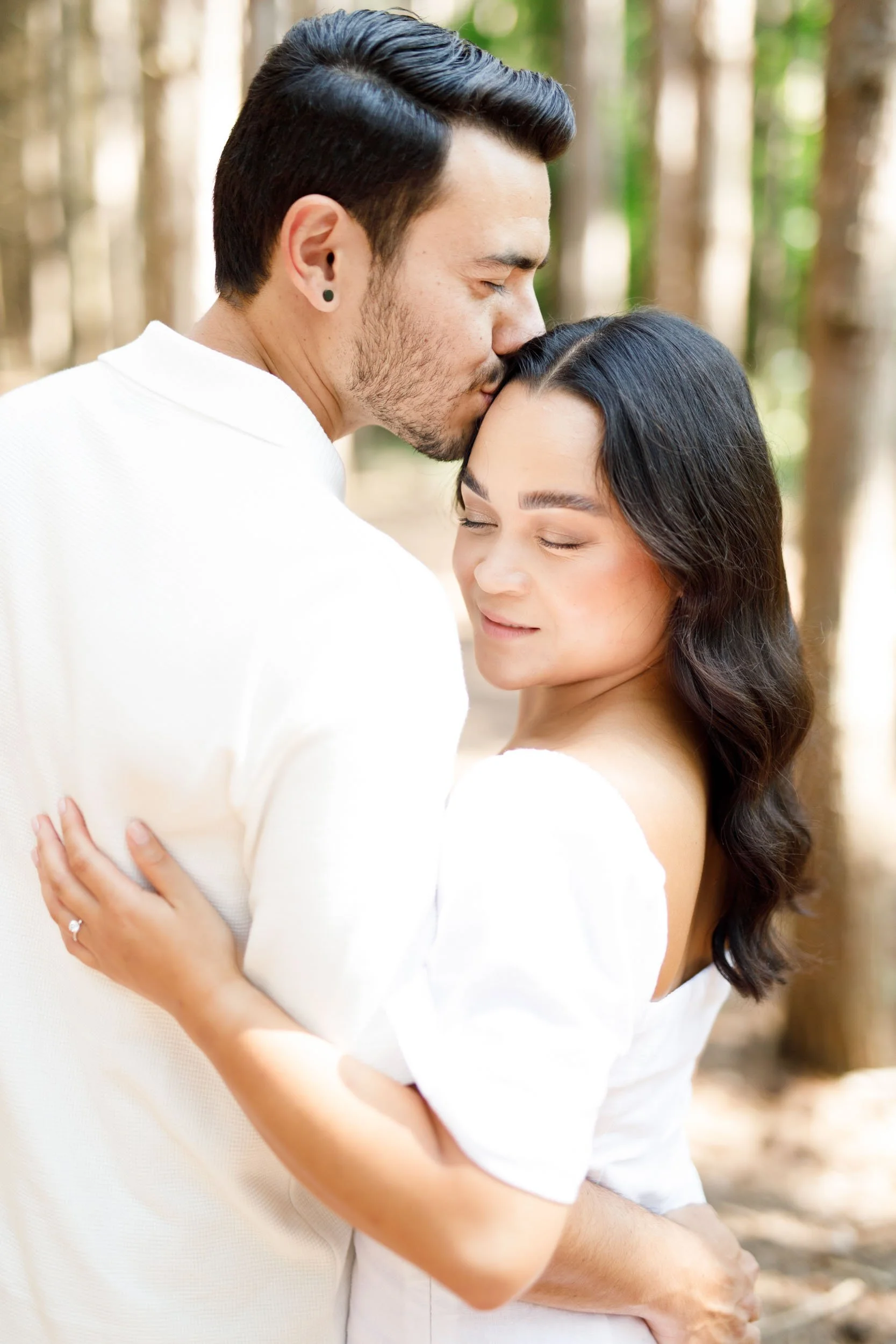 Groom kissing bride’s forehead in the forest at Kortright Centre for Conservation in Woodbridge, Ontario