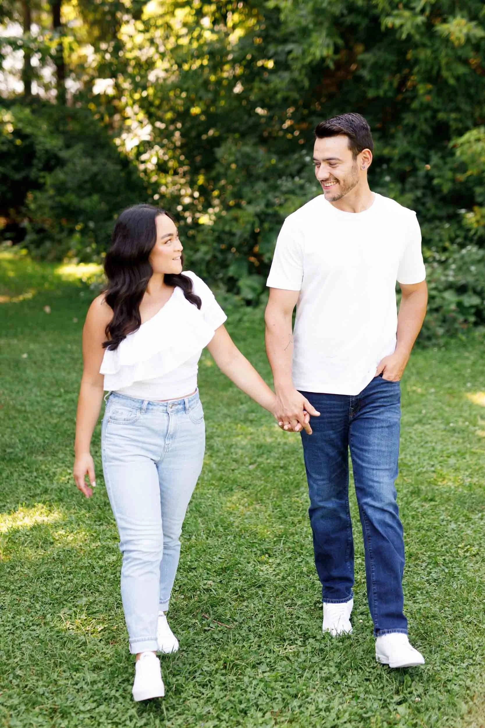 Couple holding hands while walking through a field at Kortright Centre in Woodbridge, Ontario