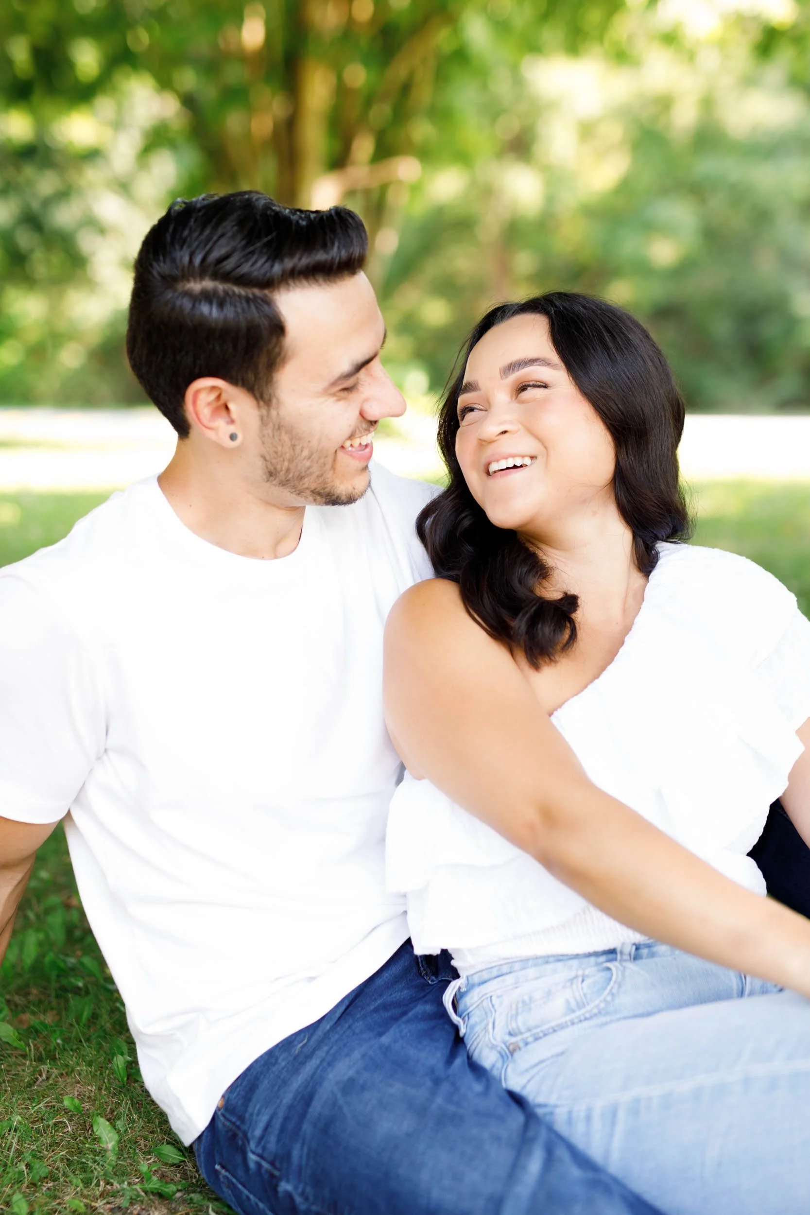 Couple laughing together on the grass during Kortright Centre engagement photos in Woodbridge, Ontario