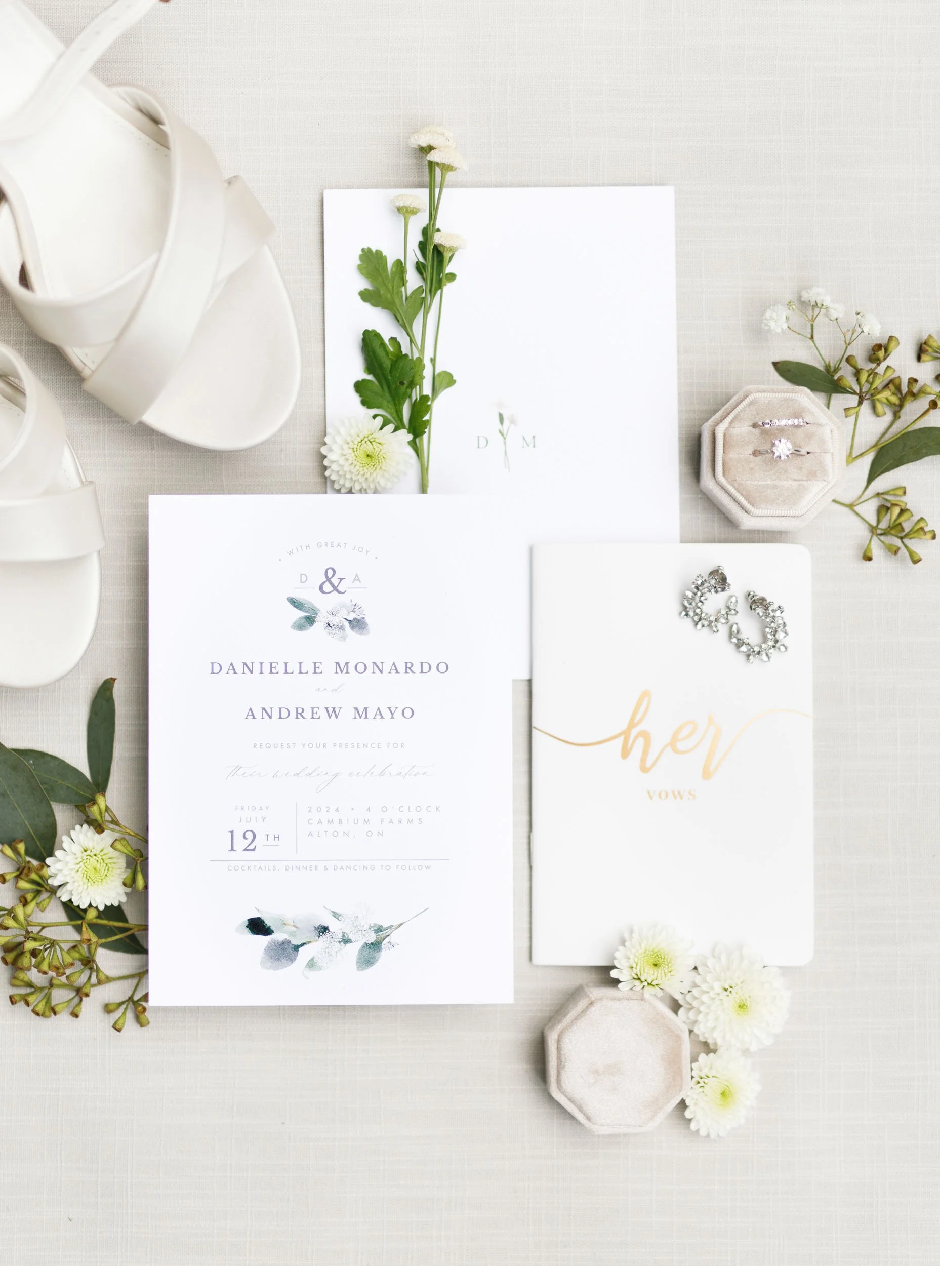 Wedding invitation suite with greenery and bride’s shoes at a romantic Cambium Farms wedding in Alton, Ontario