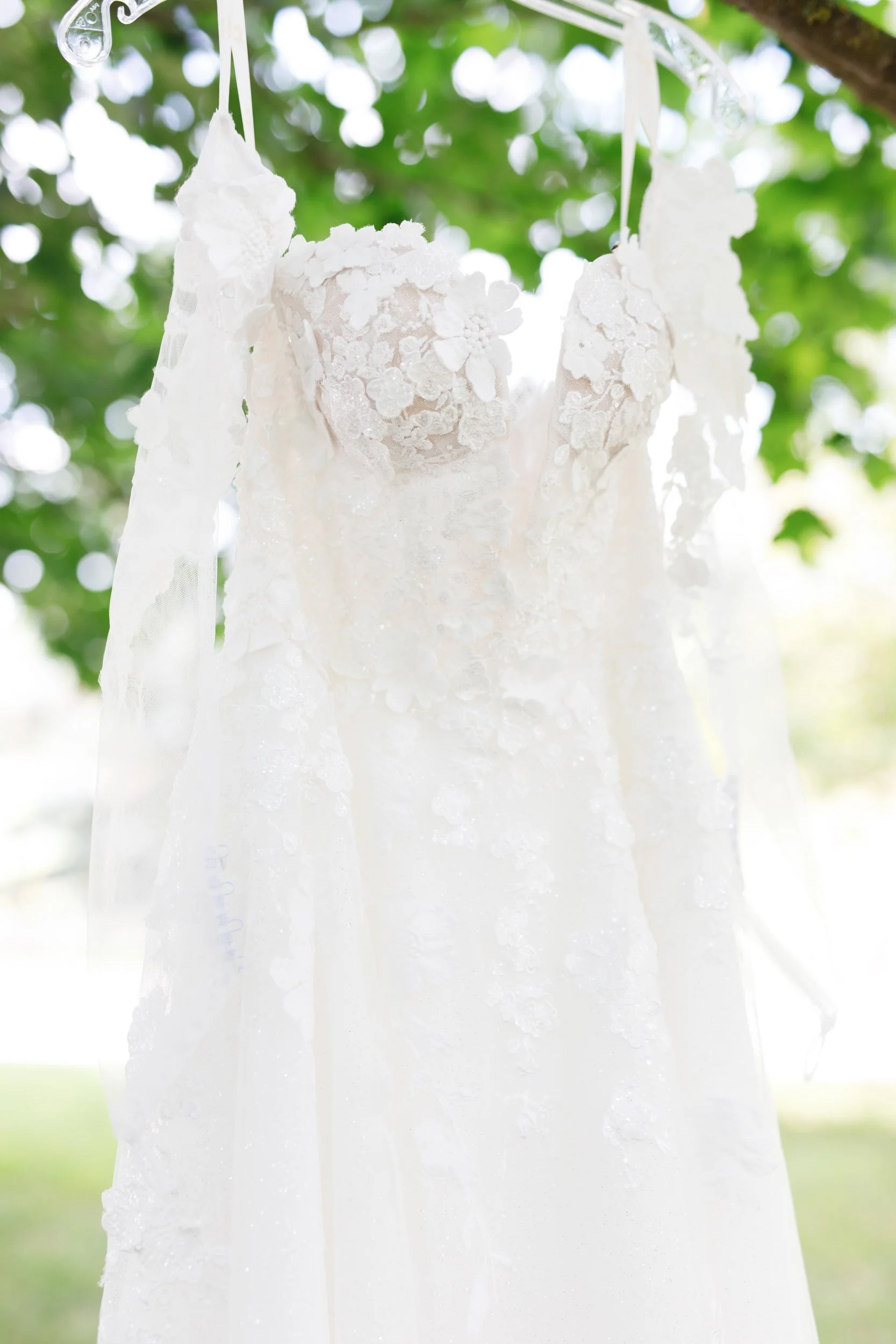 Lace wedding dress hanging outdoors at a Cambium Farms wedding in Alton, Ontario