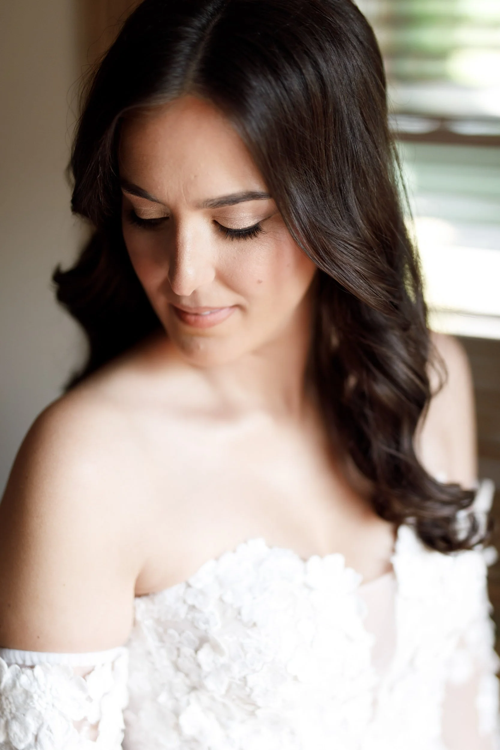 Bride looking down in her off-the-shoulder wedding gown during bridal portraits at Cambium Farms in Alton, Ontario