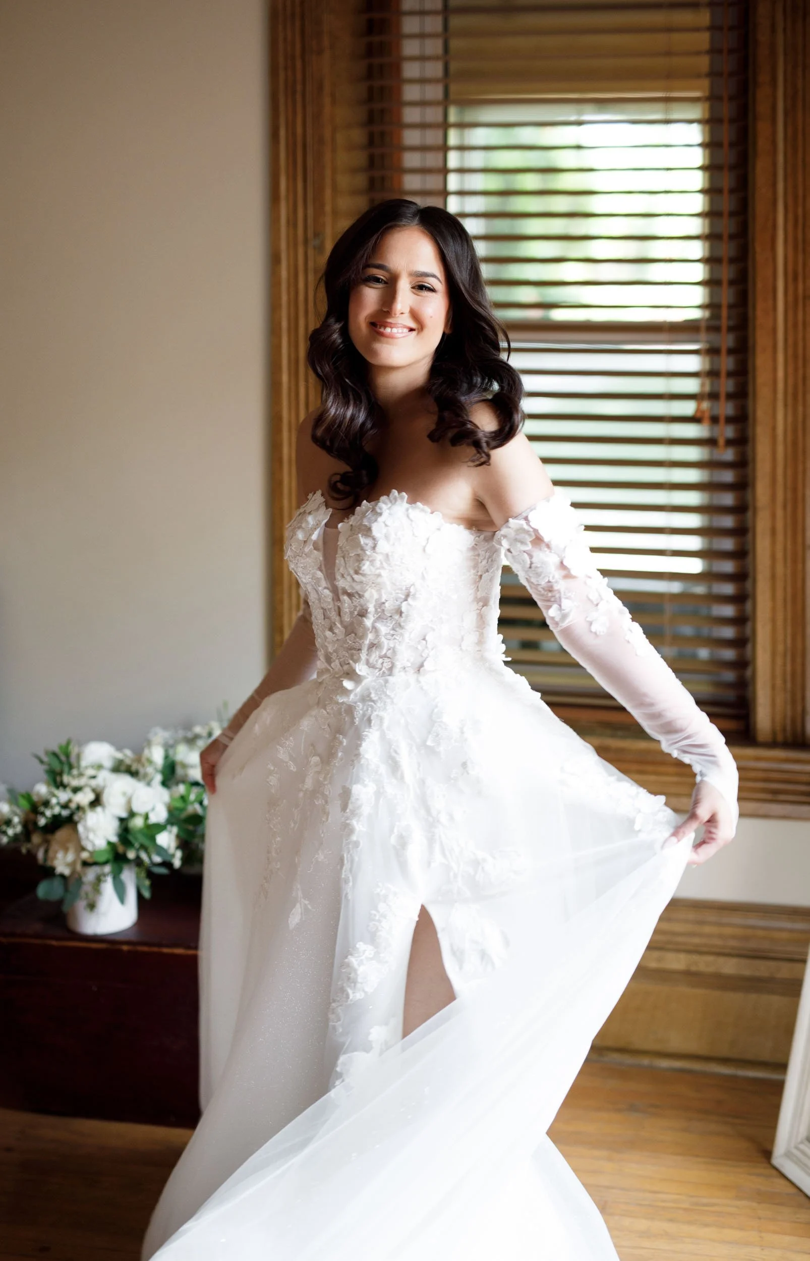 Bride standing in her wedding gown near a window at a Cambium Farms wedding in Alton, Ontario