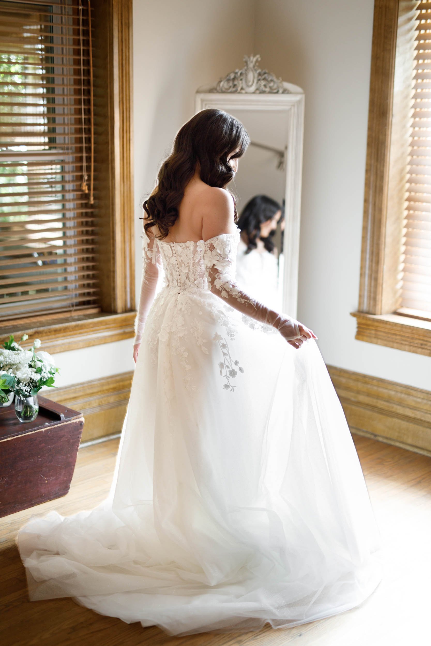 Bride twirling in her wedding dress in front of a mirror at a Cambium Farms wedding in Alton, Ontario