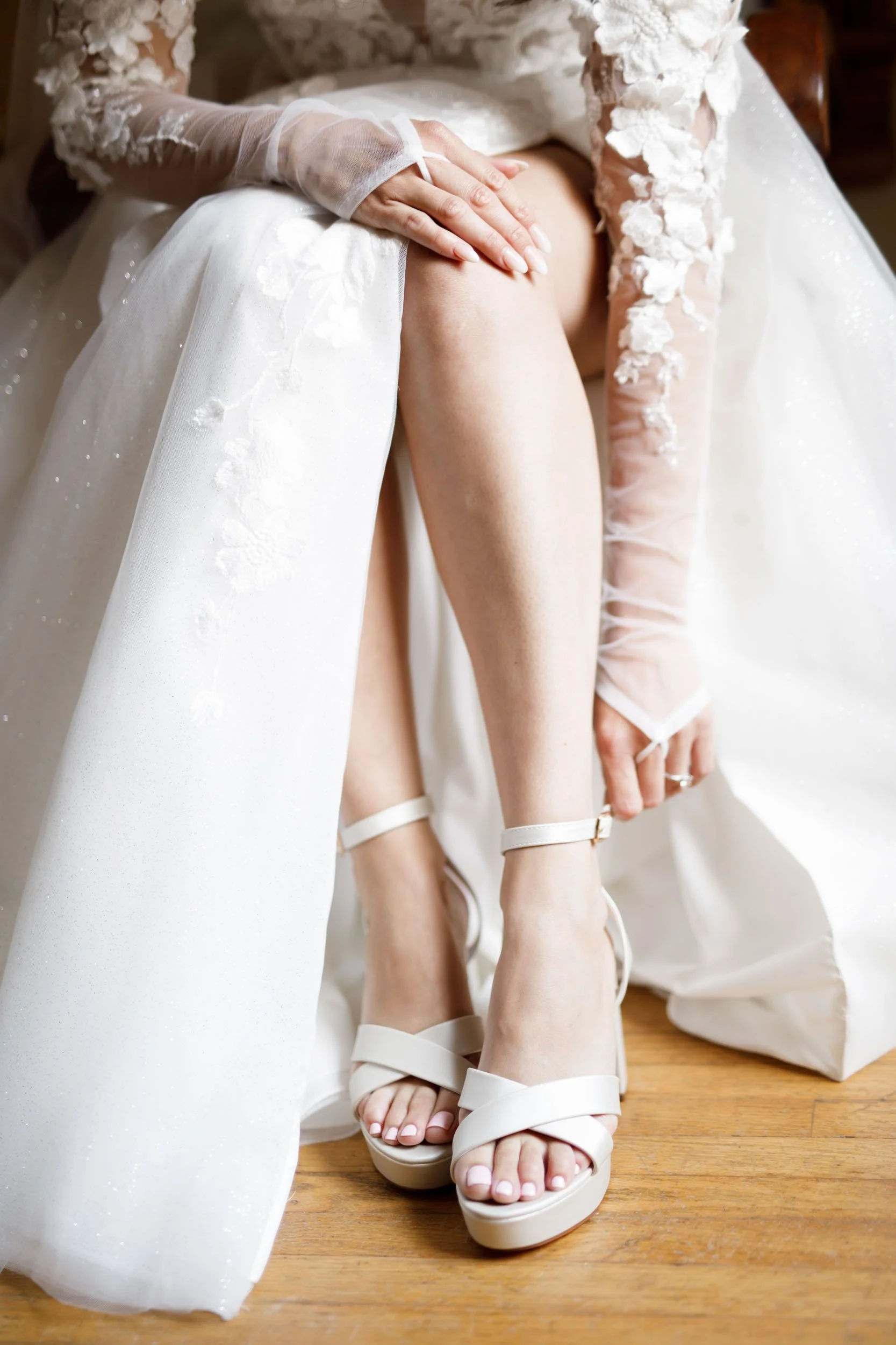 Close-up of bride’s wedding heels and lace sleeves during a Cambium Farms wedding in Alton, Ontario
