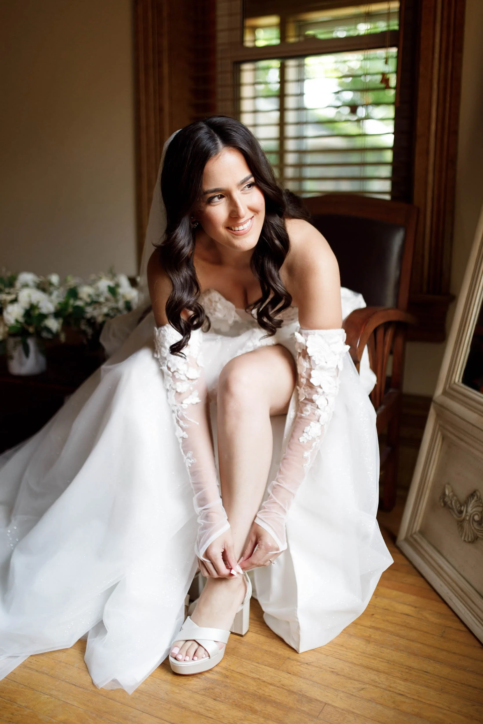 Bride fastening her wedding shoes in her gown at a Cambium Farms wedding in Alton, Ontario