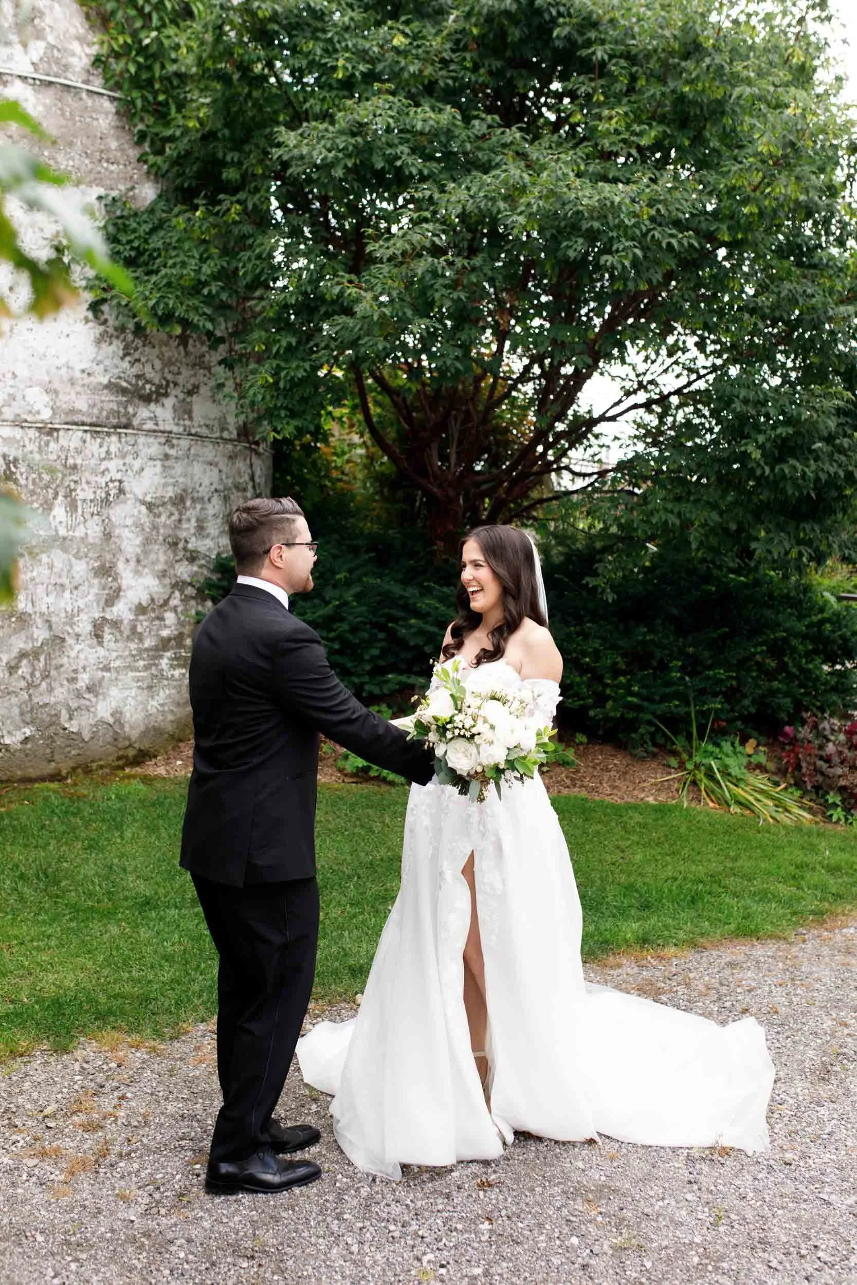 Bride reaching for groom during their first look at a Cambium Farms wedding in Alton, Ontario