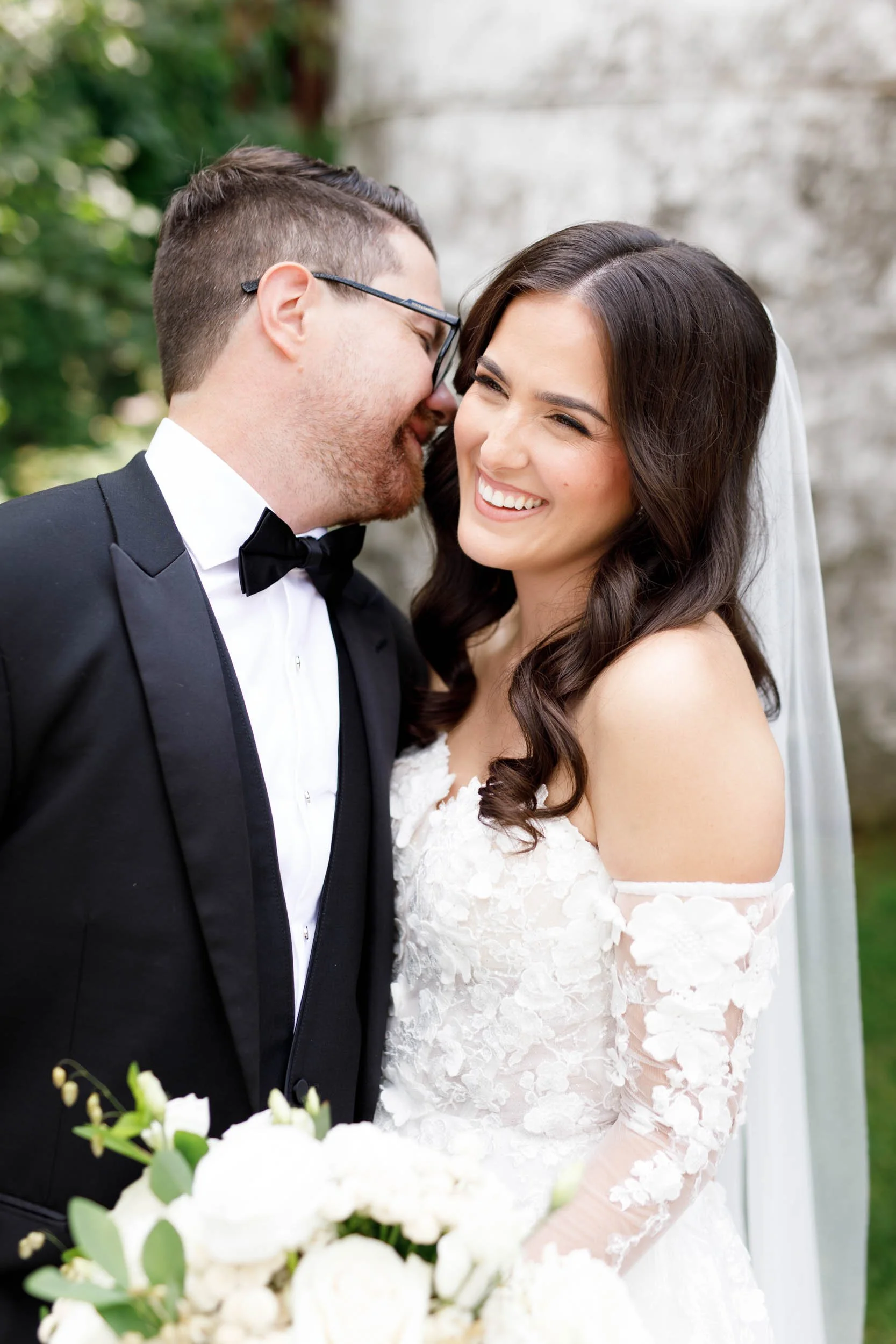Groom kissing bride on the cheek during portraits at a Cambium Farms wedding in Alton, Ontario