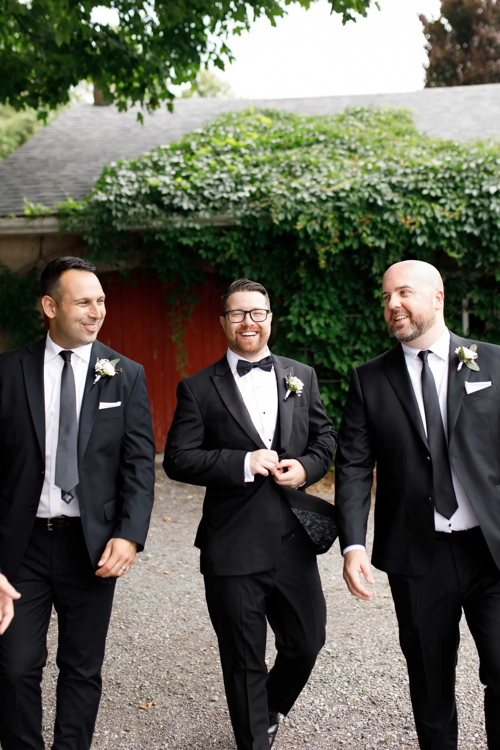 Groomsmen laughing together during wedding portraits at Cambium Farms in Alton, Ontario