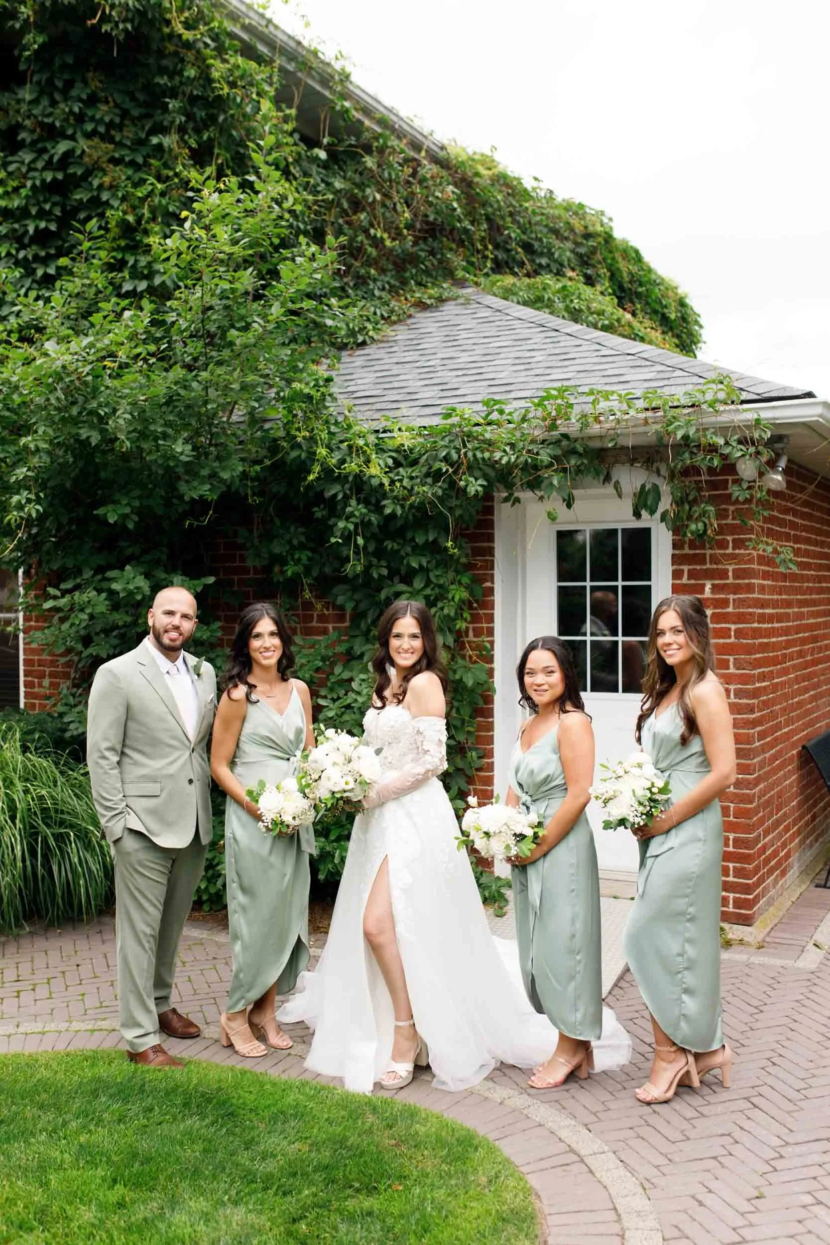 Bride and bridal party walking together during wedding portraits at Cambium Farms in Alton, Ontario
