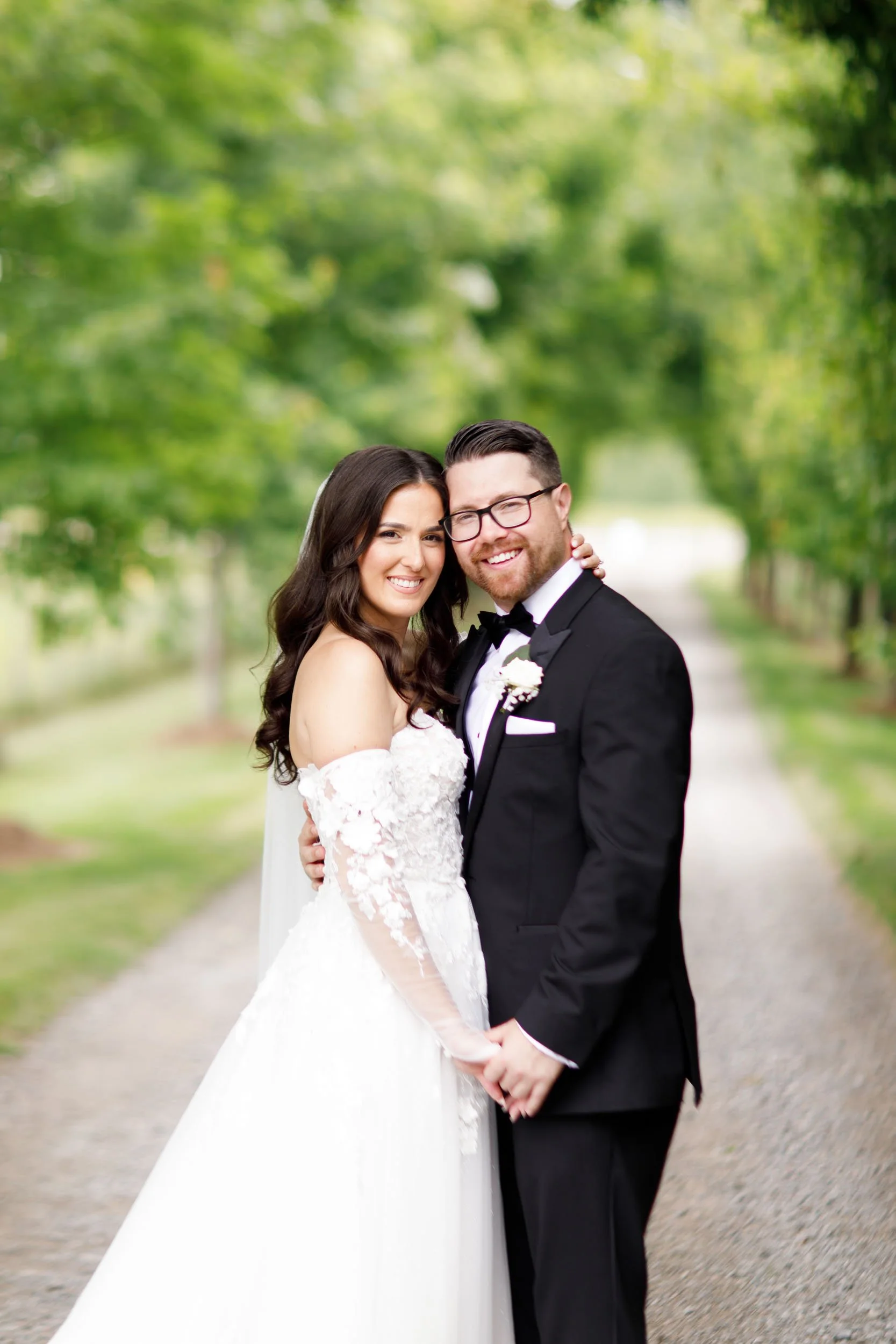 Bride and groom holding hands and smiling during portraits at a Cambium Farms wedding in Alton, Ontario