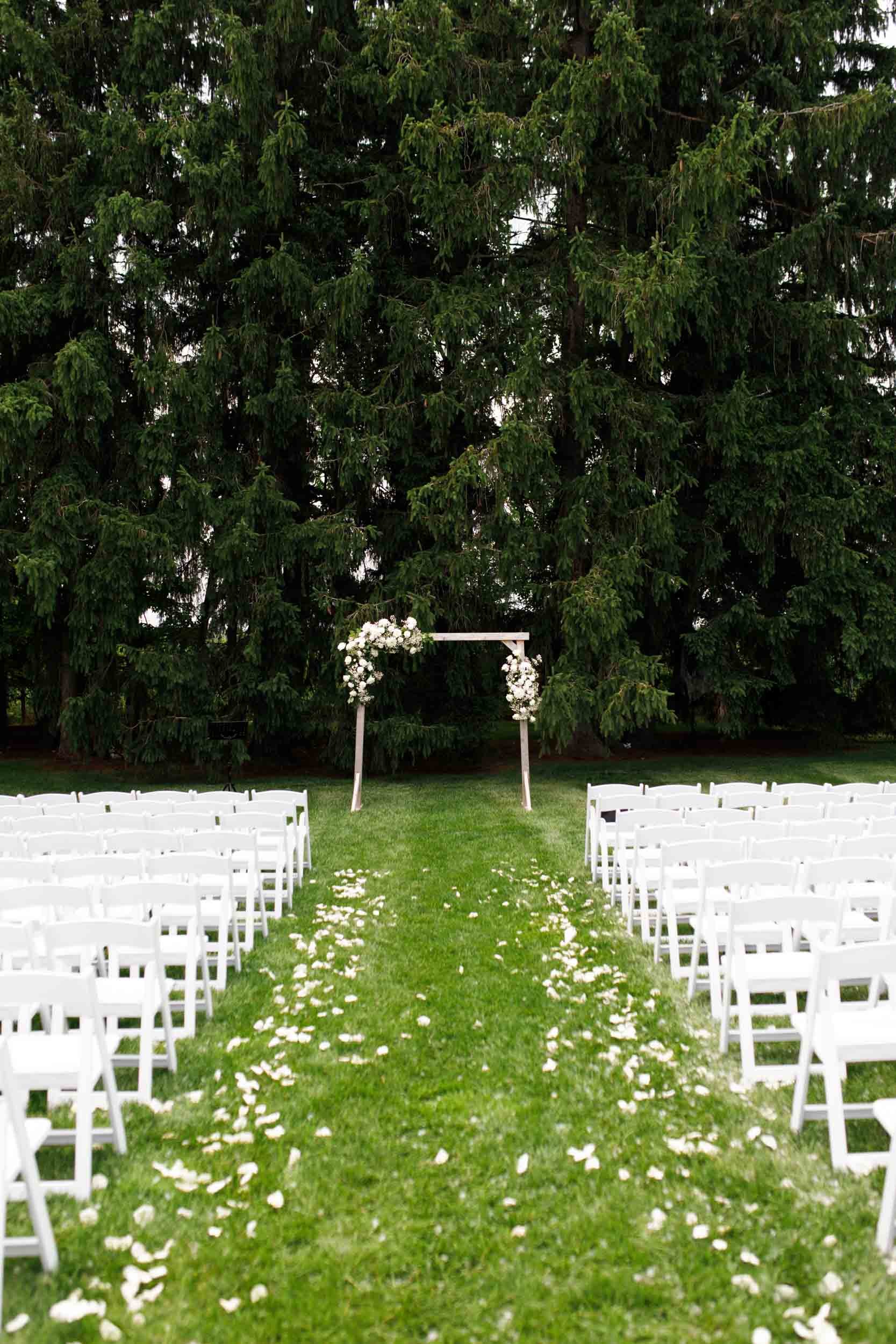 Wedding ceremony aisle lined with white chairs at Cambium Farms in Alton, Ontario