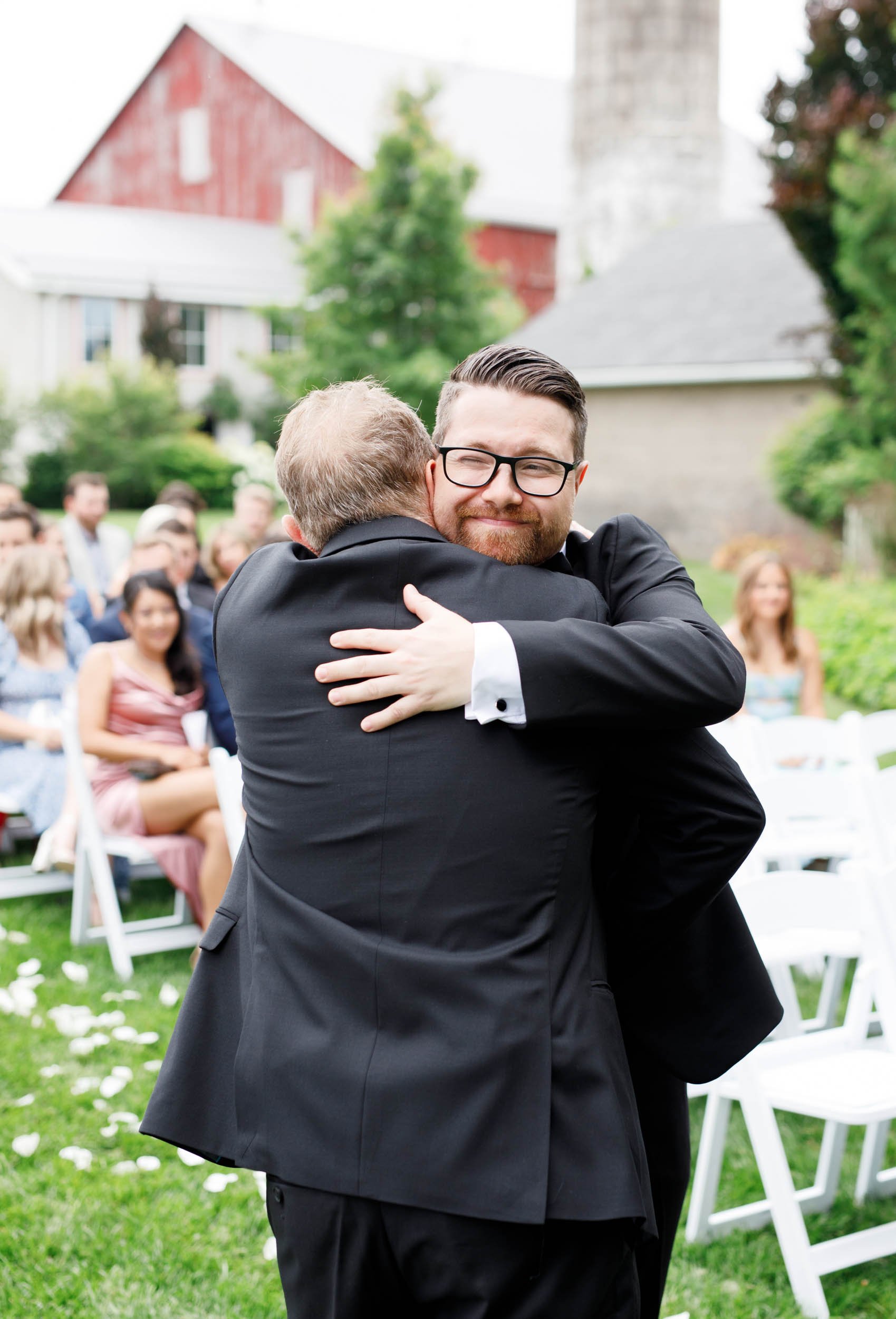 Groom hugging a family member before the ceremony at a Cambium Farms wedding in Alton, Ontario