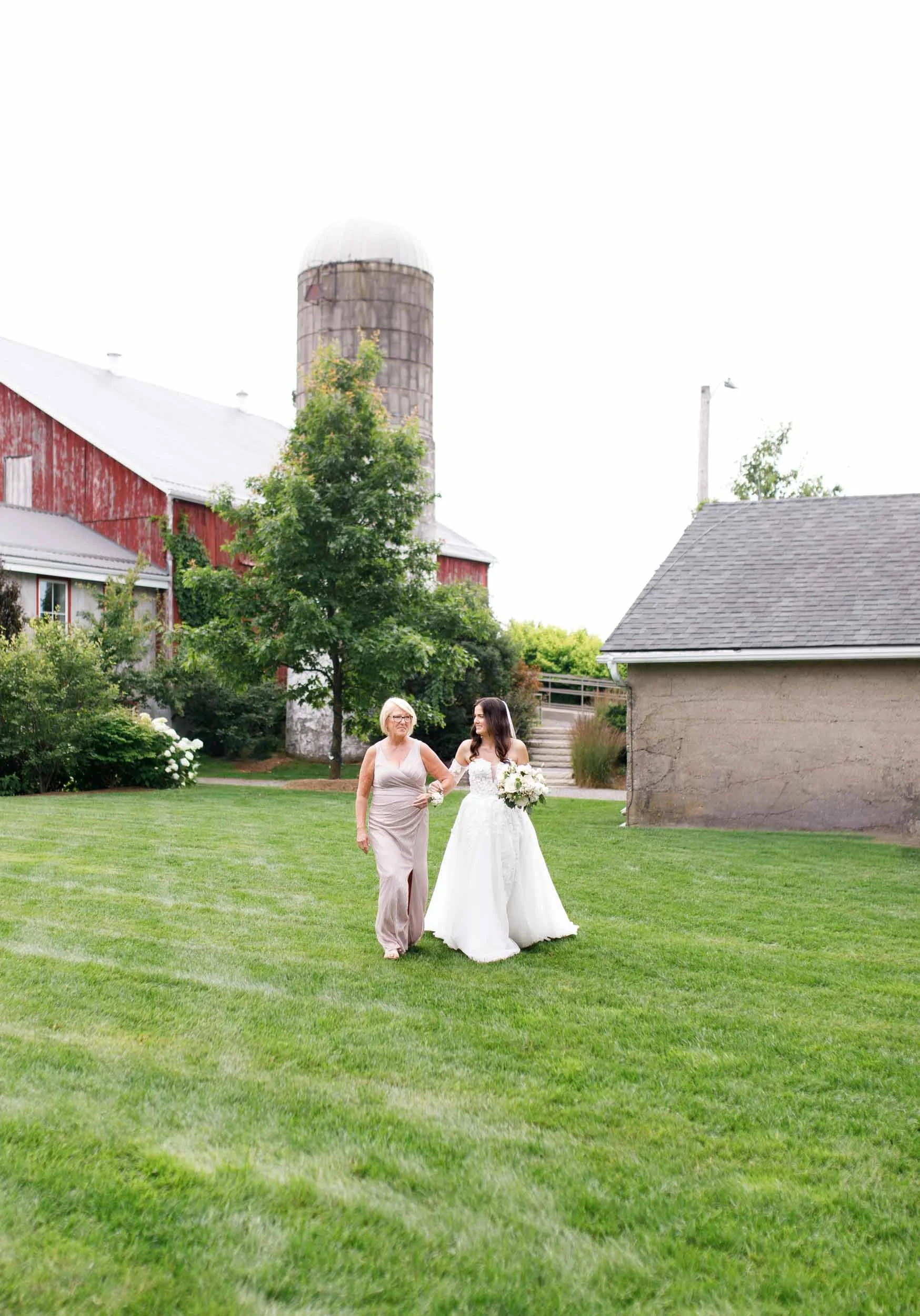 Bride walking across the lawn toward the ceremony at a Cambium Farms wedding in Alton, Ontario