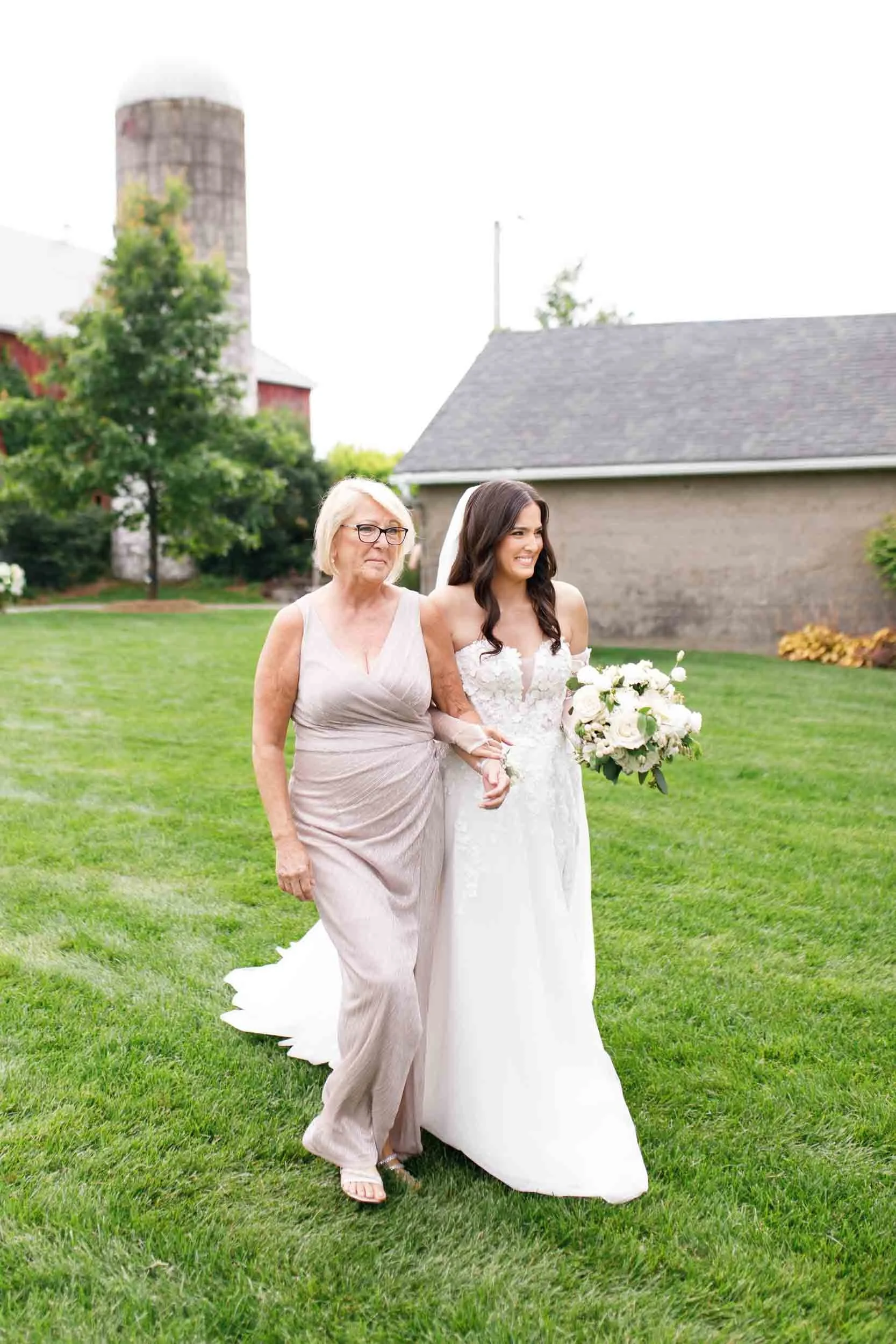 Bride walking down the aisle with her mother at a Cambium Farms wedding in Alton, Ontario