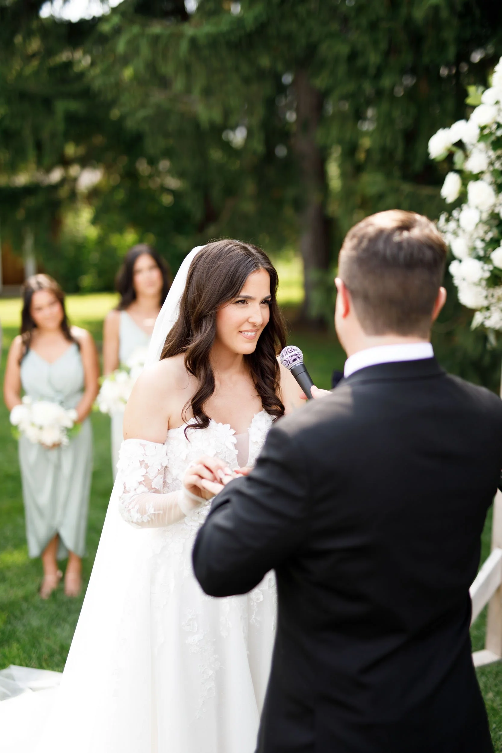 Bride smiling at groom during their wedding ceremony at Cambium Farms in Alton, Ontario
