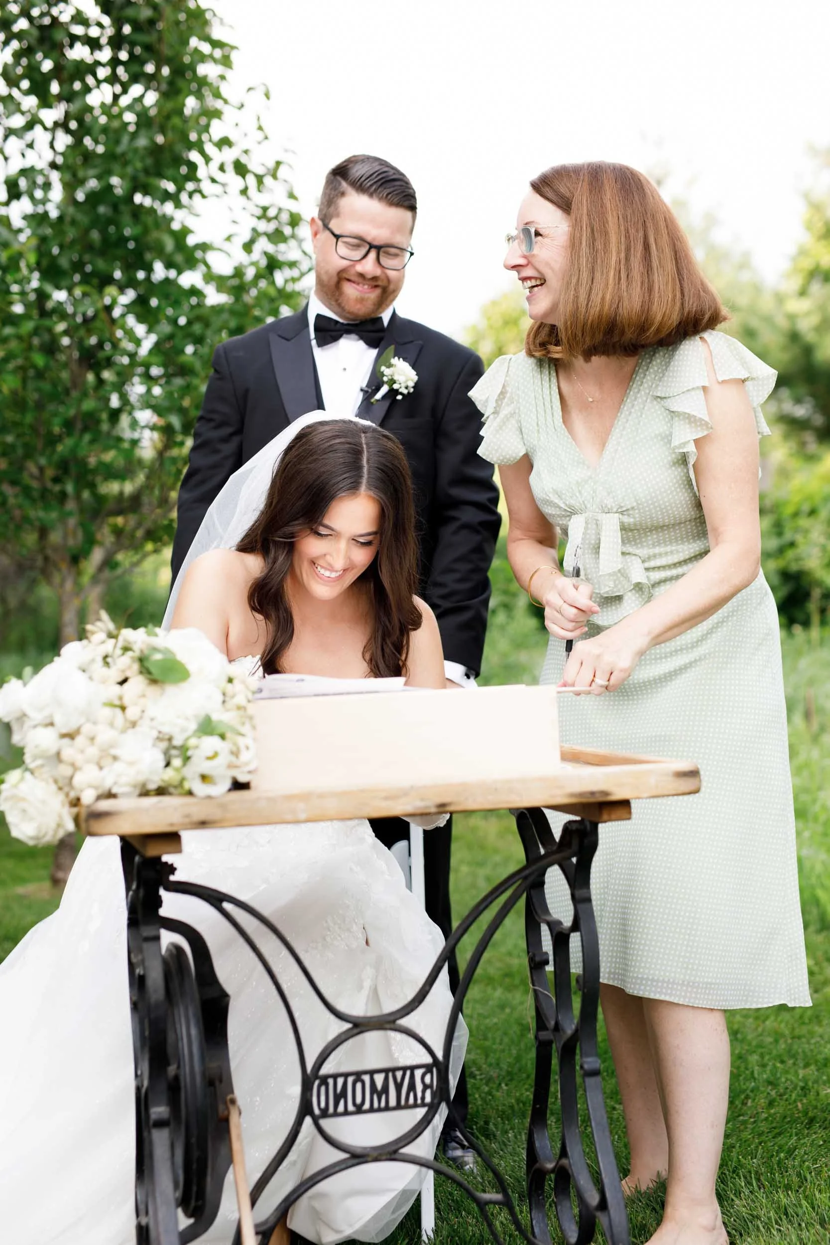 Bride signing the marriage register during a Cambium Farms wedding in Alton, Ontario