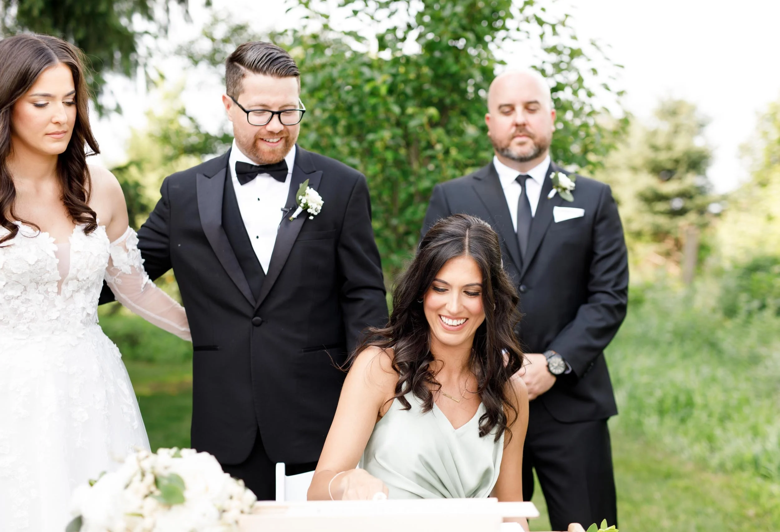 Wedding witnesses and bridal party watching as the register is signed at Cambium Farms in Alton, Ontario