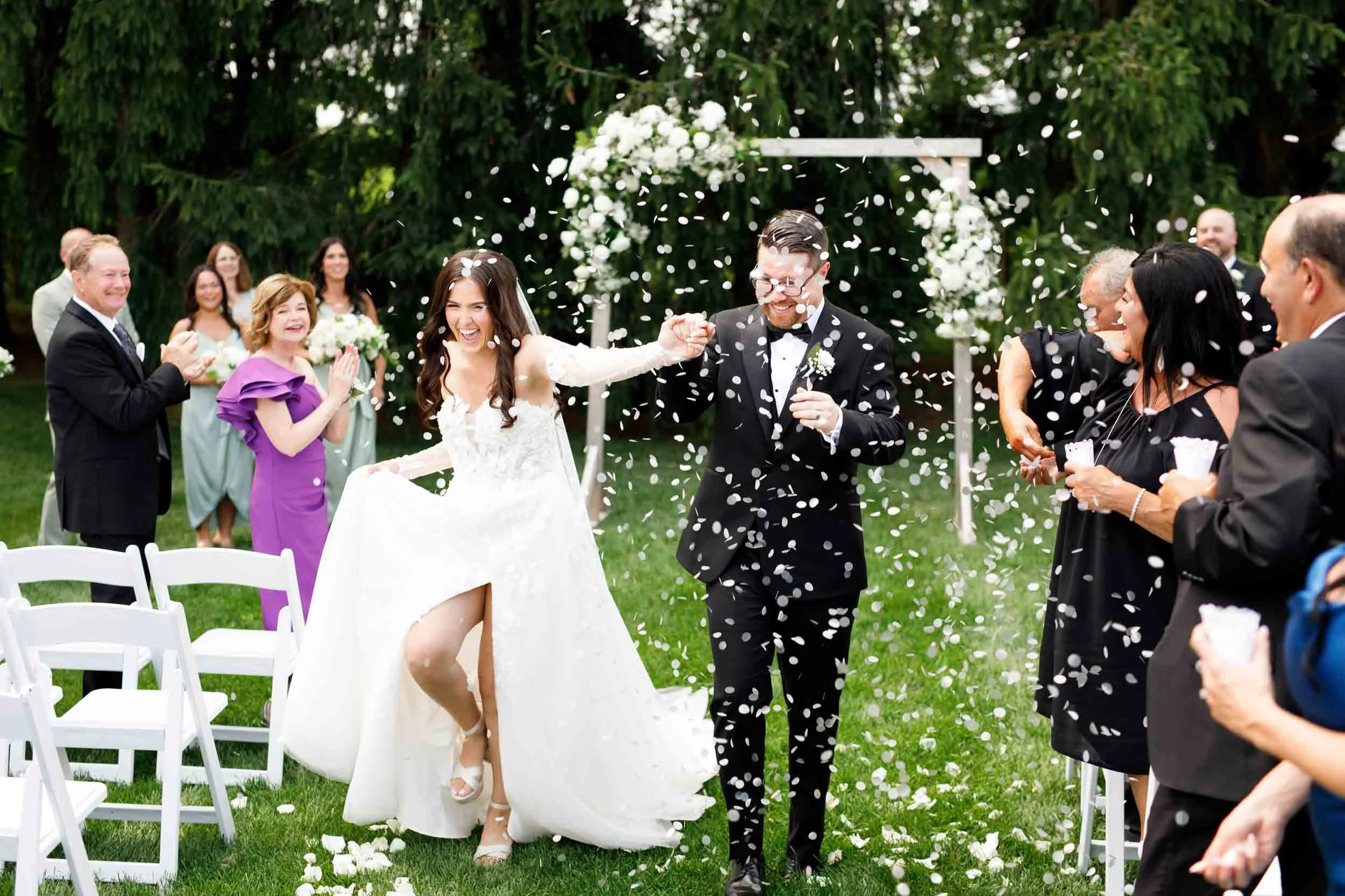 Bride and groom celebrating during their confetti exit at a Cambium Farms wedding in Alton, Ontario