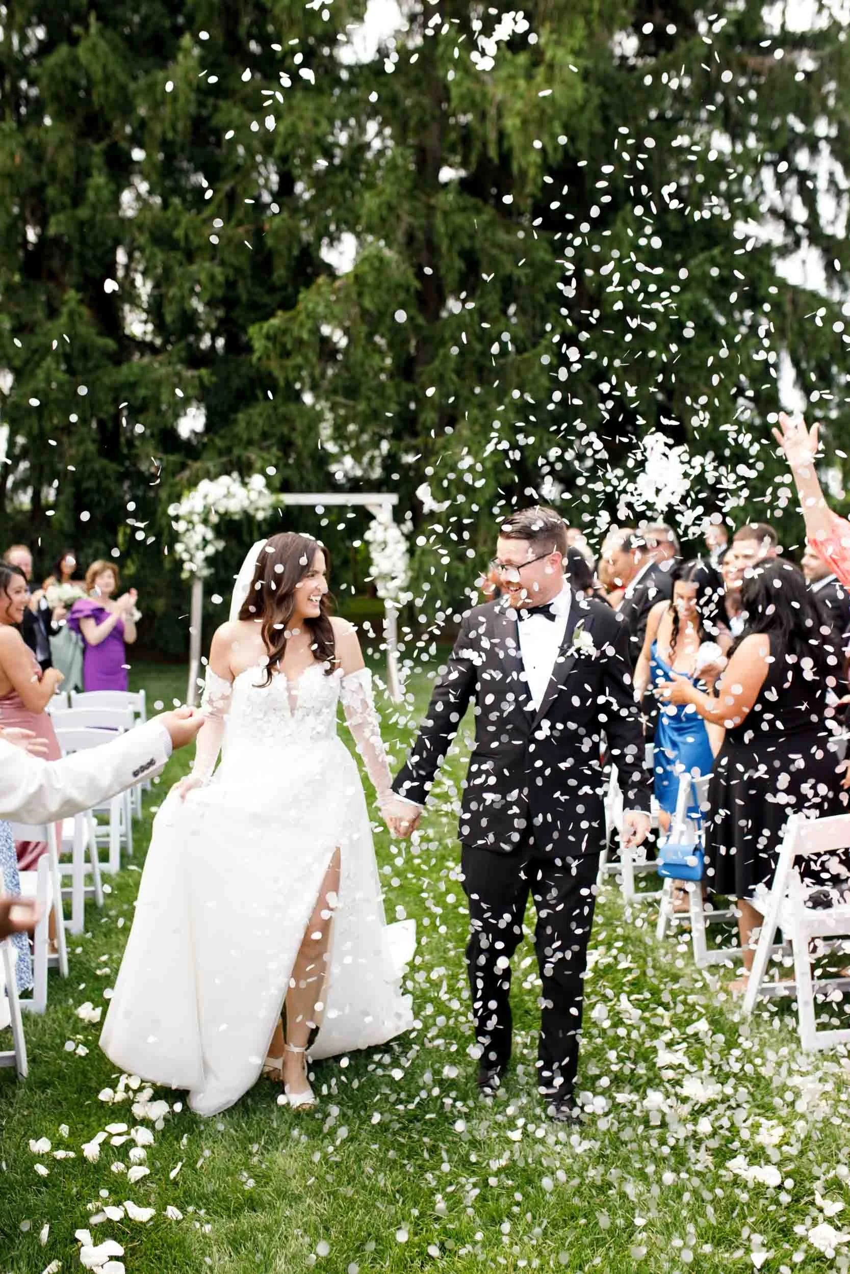 Bride and groom walking through falling confetti after their Cambium Farms ceremony in Alton, Ontario