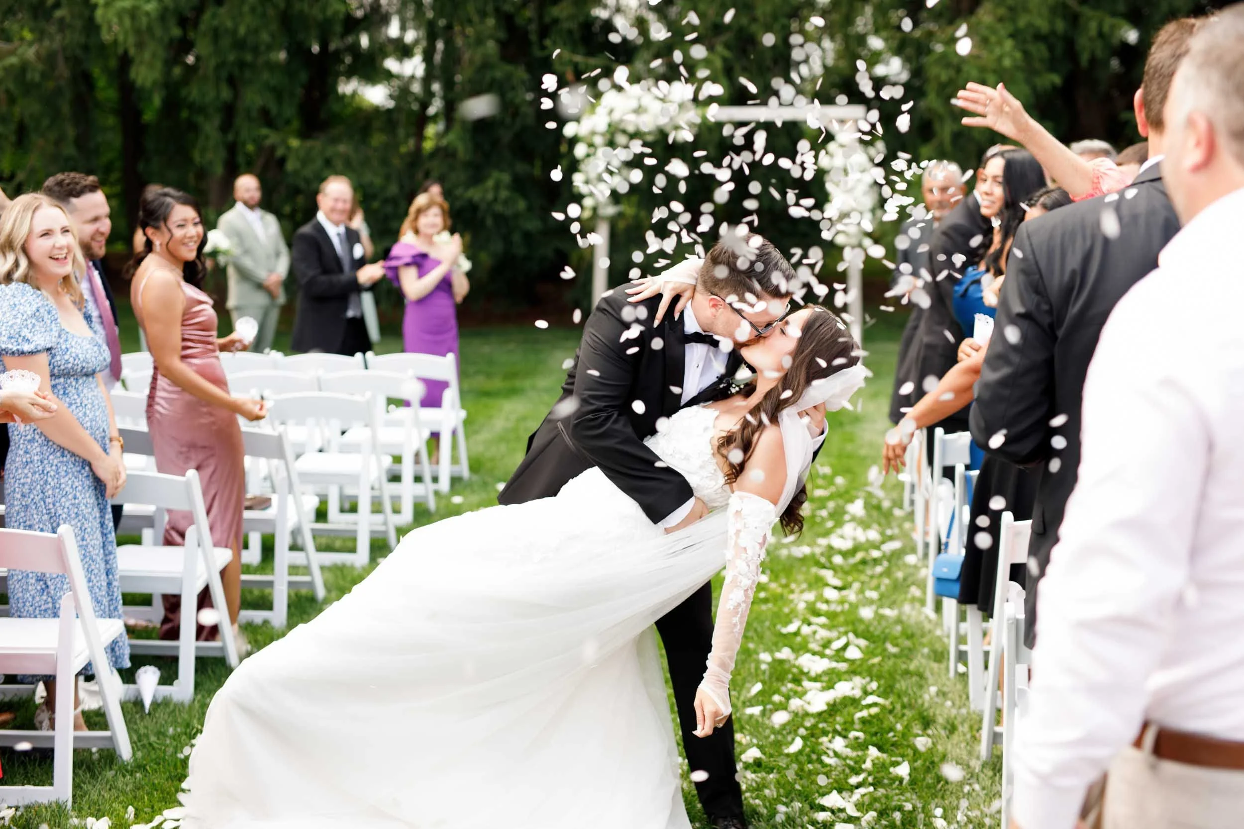 Bride and groom laughing as guests throw confetti at a Cambium Farms wedding in Alton, Ontario