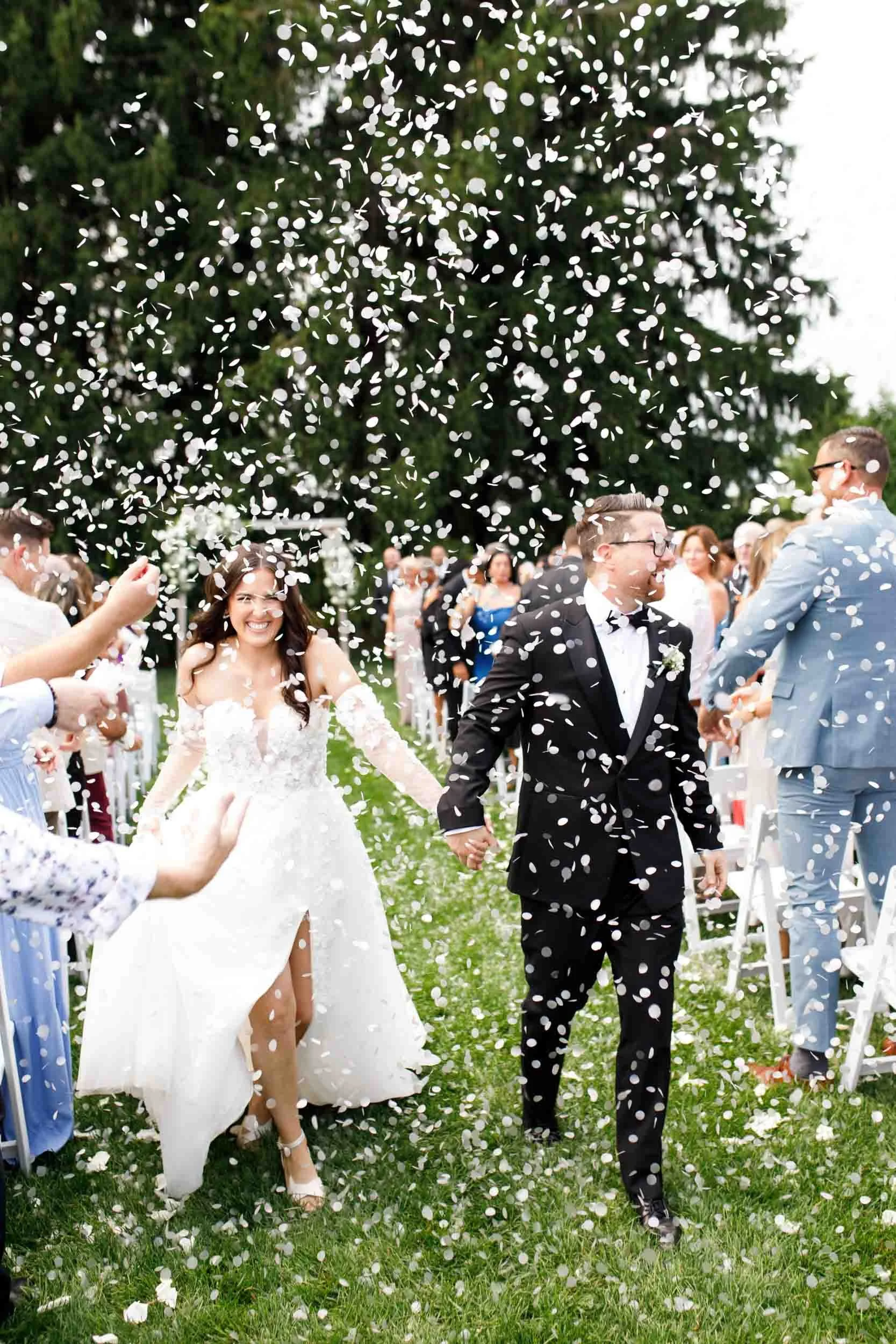 Bride and groom walking through confetti at their Cambium Farms wedding in Alton, Ontario
