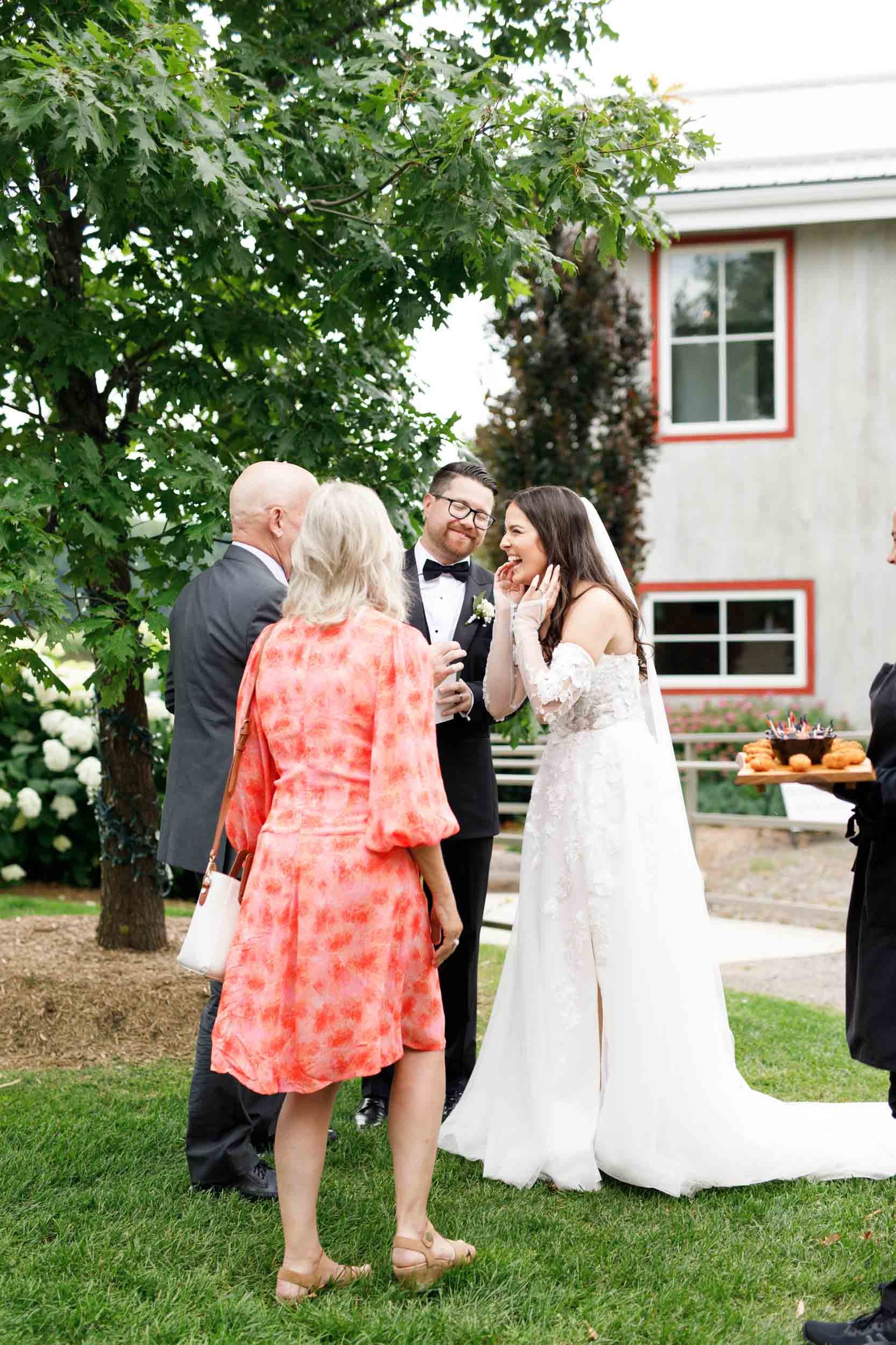Bride greeting family members during cocktail hour at a Cambium Farms wedding in Alton, Ontario