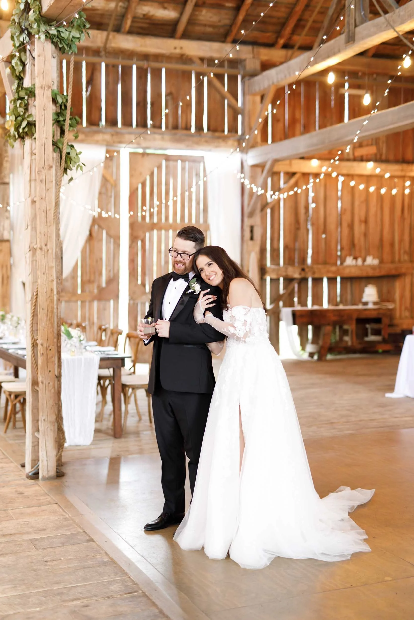Bride and groom standing together inside the Cambium Farms barn during their reception in Alton, Ontario