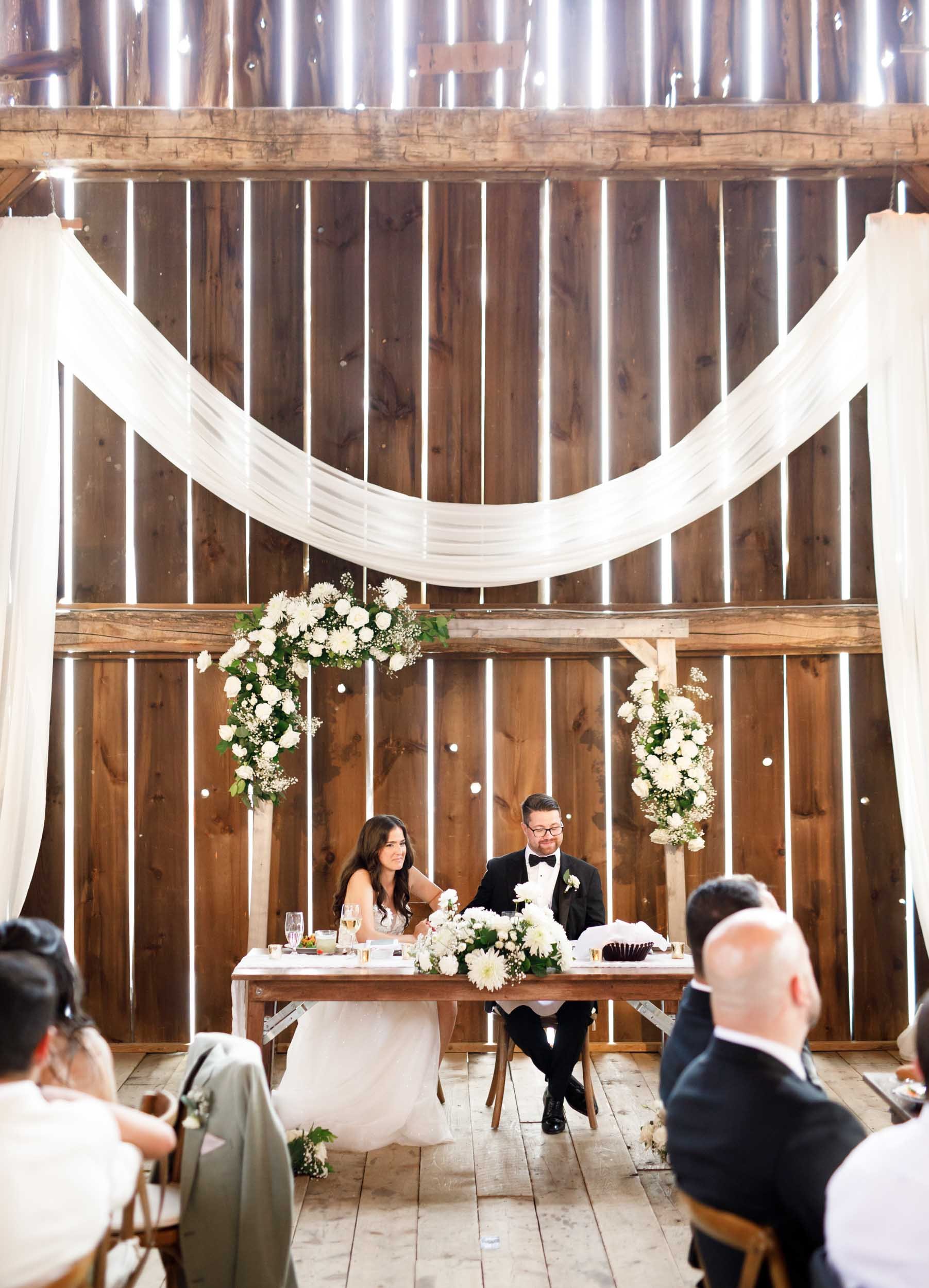 Wide view of the sweetheart table and décor inside the Cambium Farms barn in Alton, Ontario