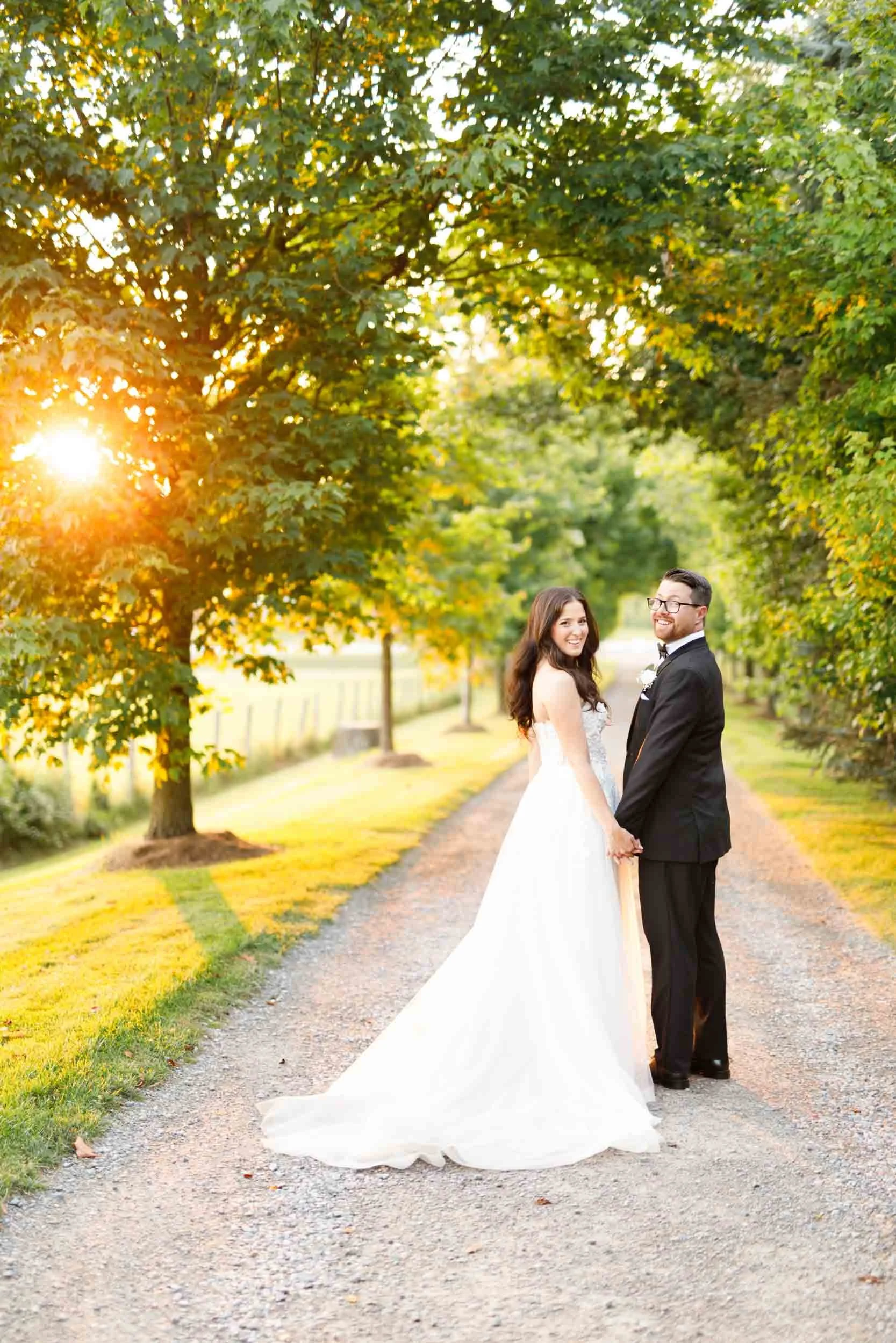 Bride and groom posing beneath trees during golden hour at a Cambium Farms wedding in Alton, Ontario