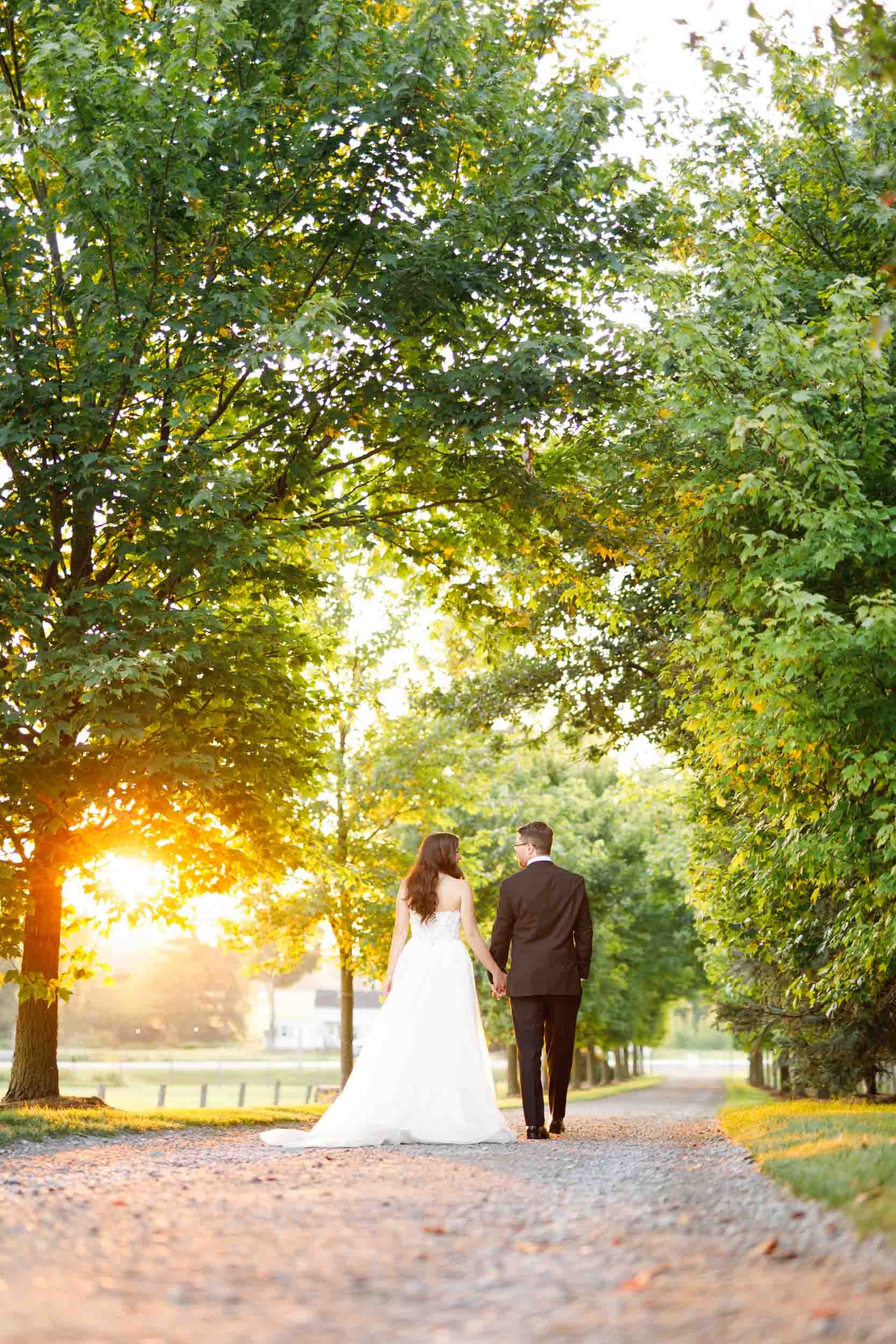 Bride and groom sharing a kiss beneath trees at sunset at Cambium Farms in Alton, Ontario