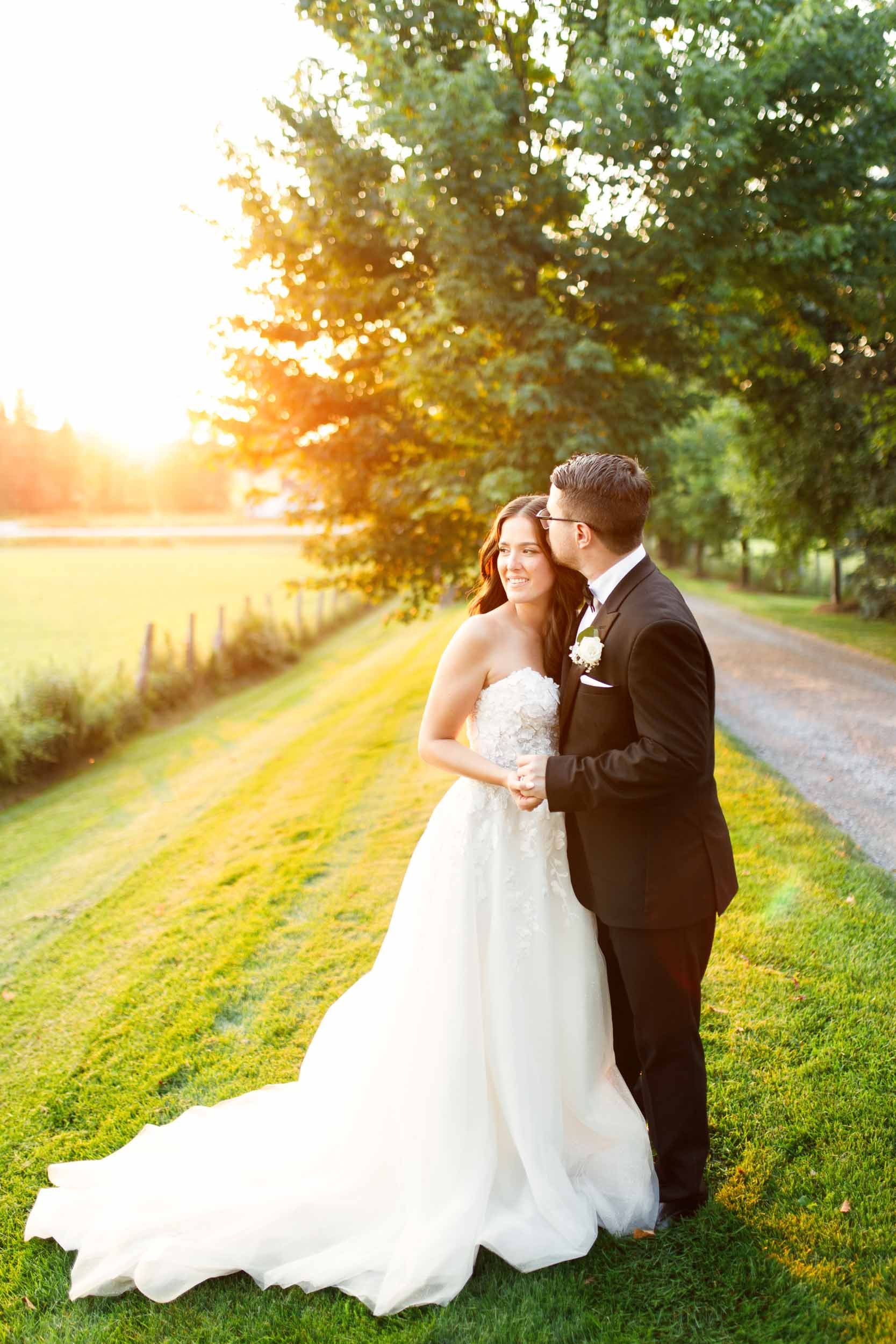 Bride and groom standing together in glowing sunset light at Cambium Farms in Alton, Ontario