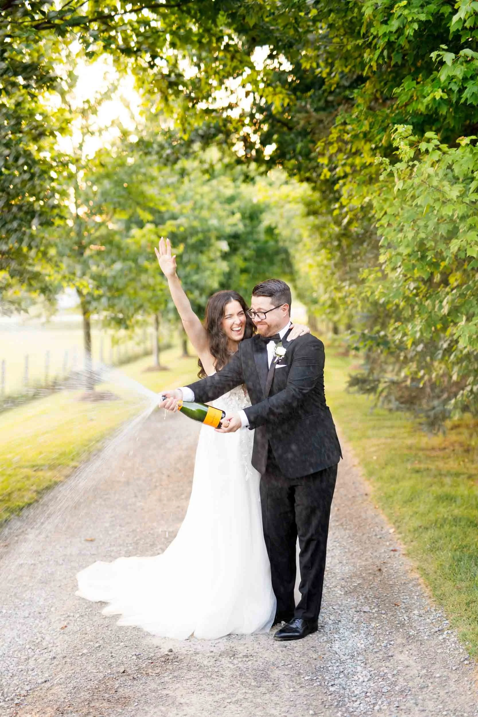 Bride and groom celebrating with champagne during golden hour at Cambium Farms in Alton, Ontario